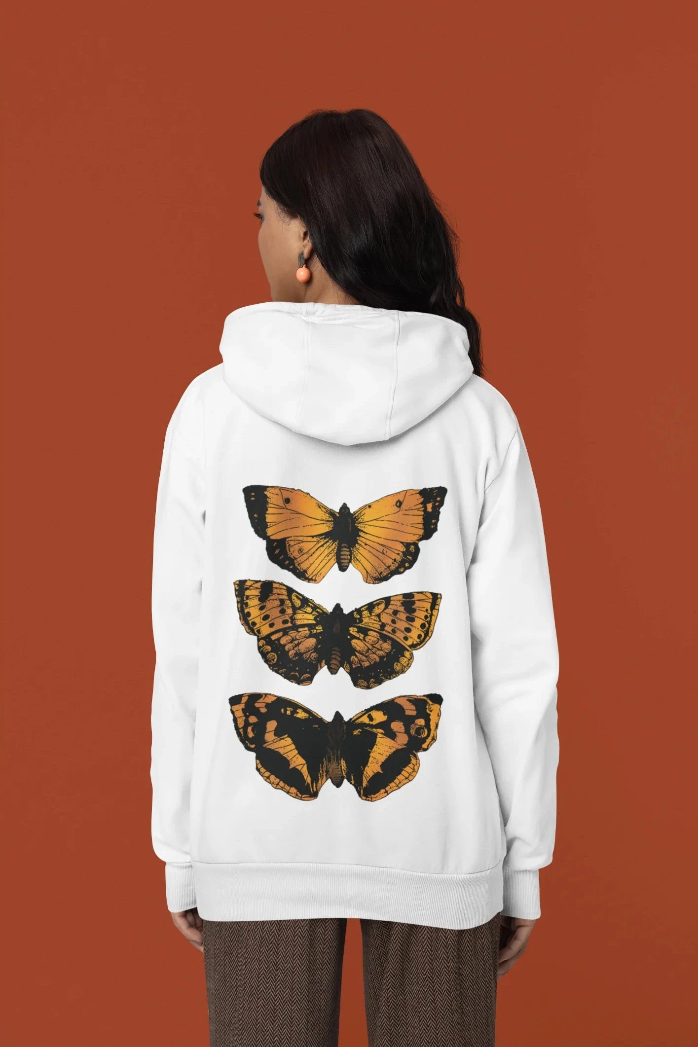 Back view of a female model wearing a white hoodie with a design featuring three different types of butterflies, symbolizing the beauty and diversity of nature.