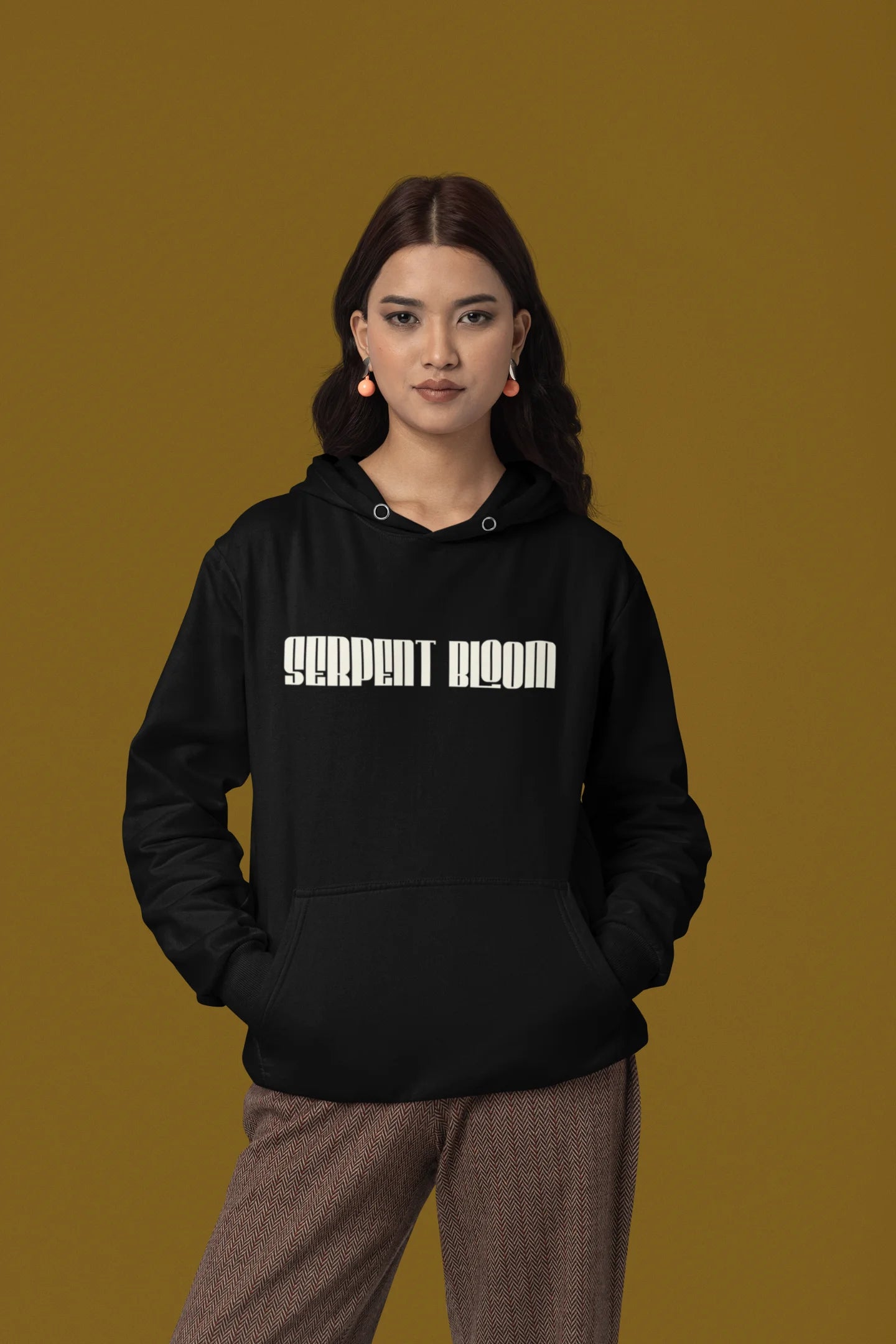 Second front view of a female model wearing a black hoodie with a snake coiled around flowers, symbolizing the harmony between nature and its creatures.