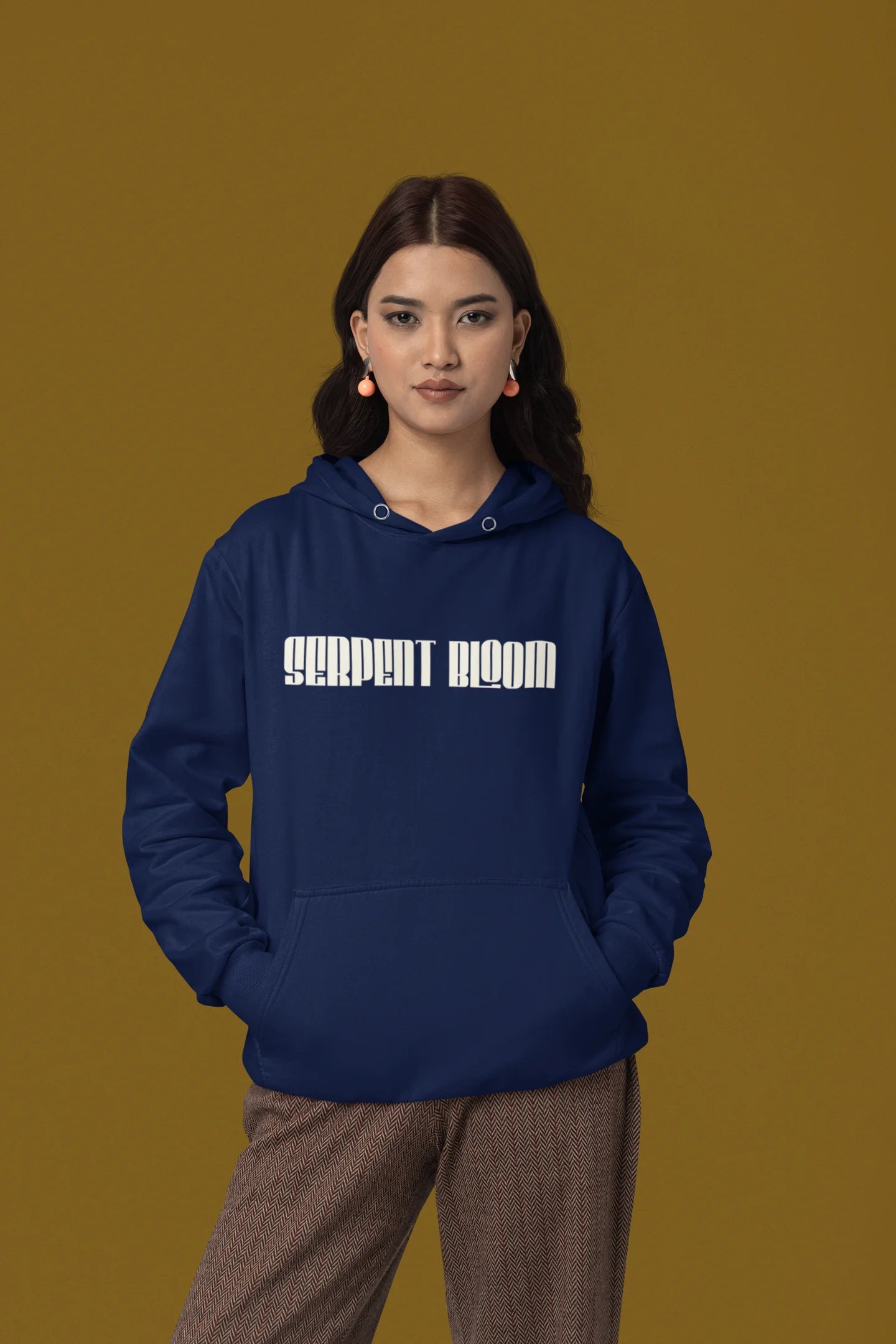Third front of female model wearing a navy blue hoodie with a snake coiled around flowers, symbolizing the harmony between nature and its creatures.