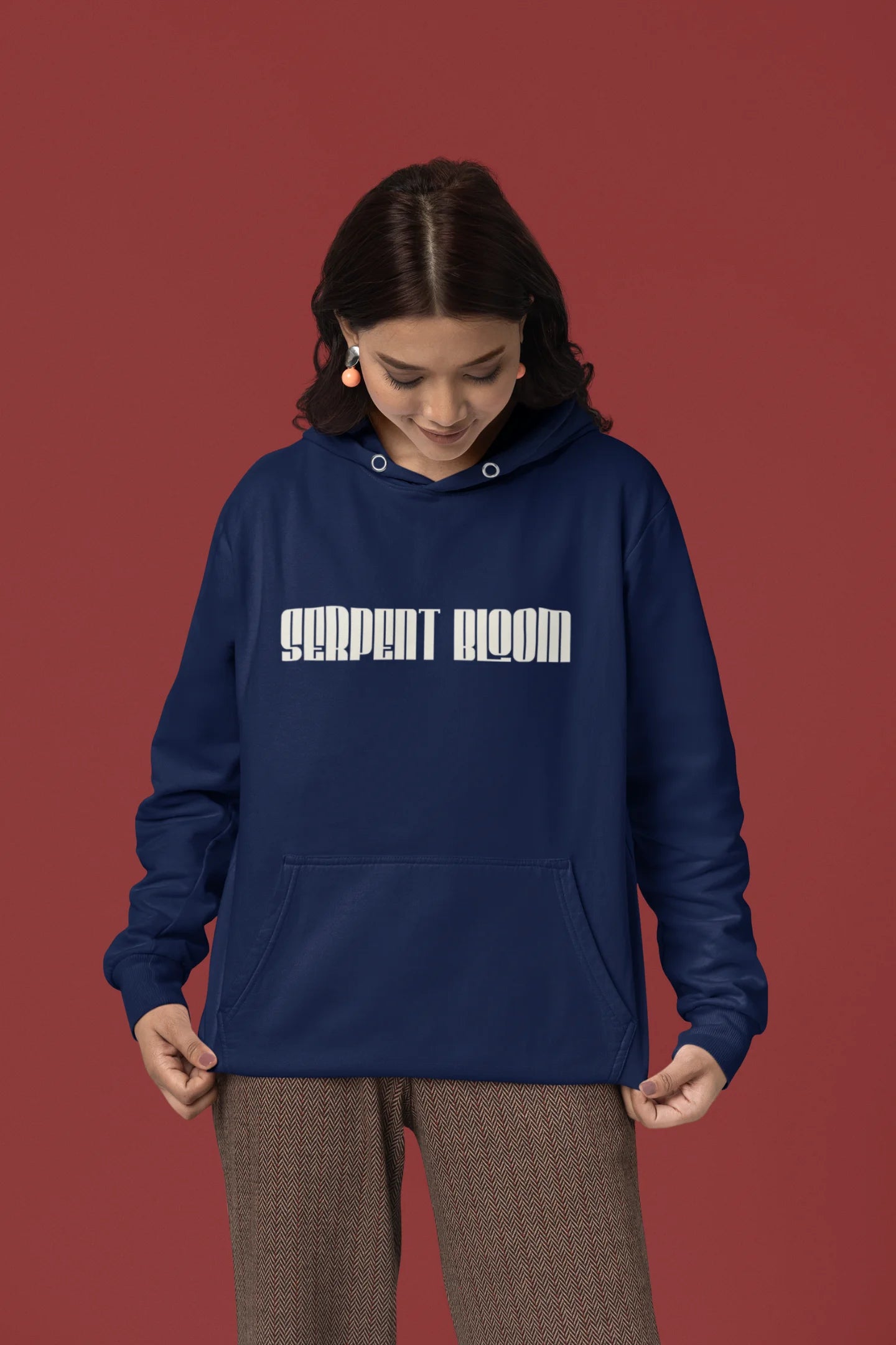 Second front of female model wearing a navy blue hoodie with a snake coiled around flowers, symbolizing the harmony between nature and its creatures.
