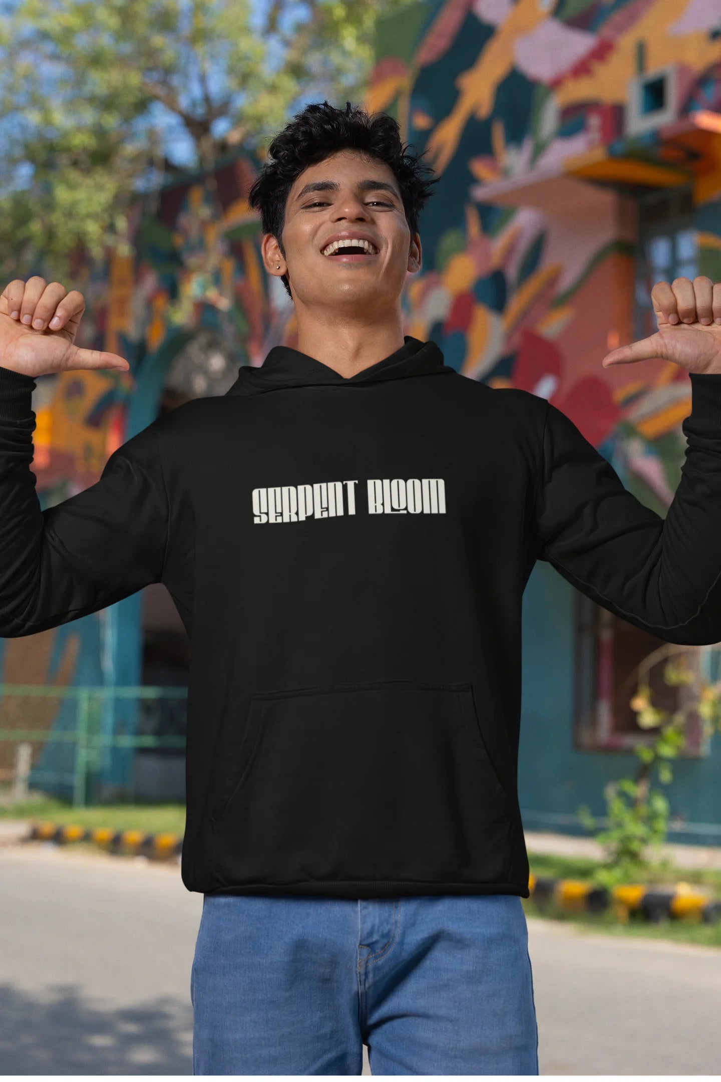 Third front of male model wearing a black hoodie with a snake coiled around flowers, symbolizing the harmony between nature and its creatures.
