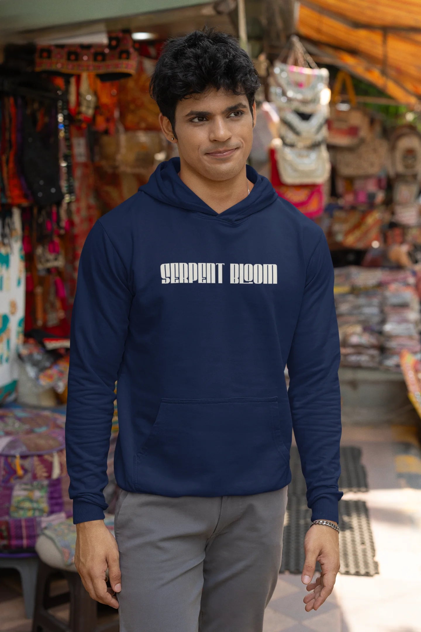 Third front of male model wearing a navy blue hoodie with a snake coiled around flowers, symbolizing the harmony between nature and its creatures.