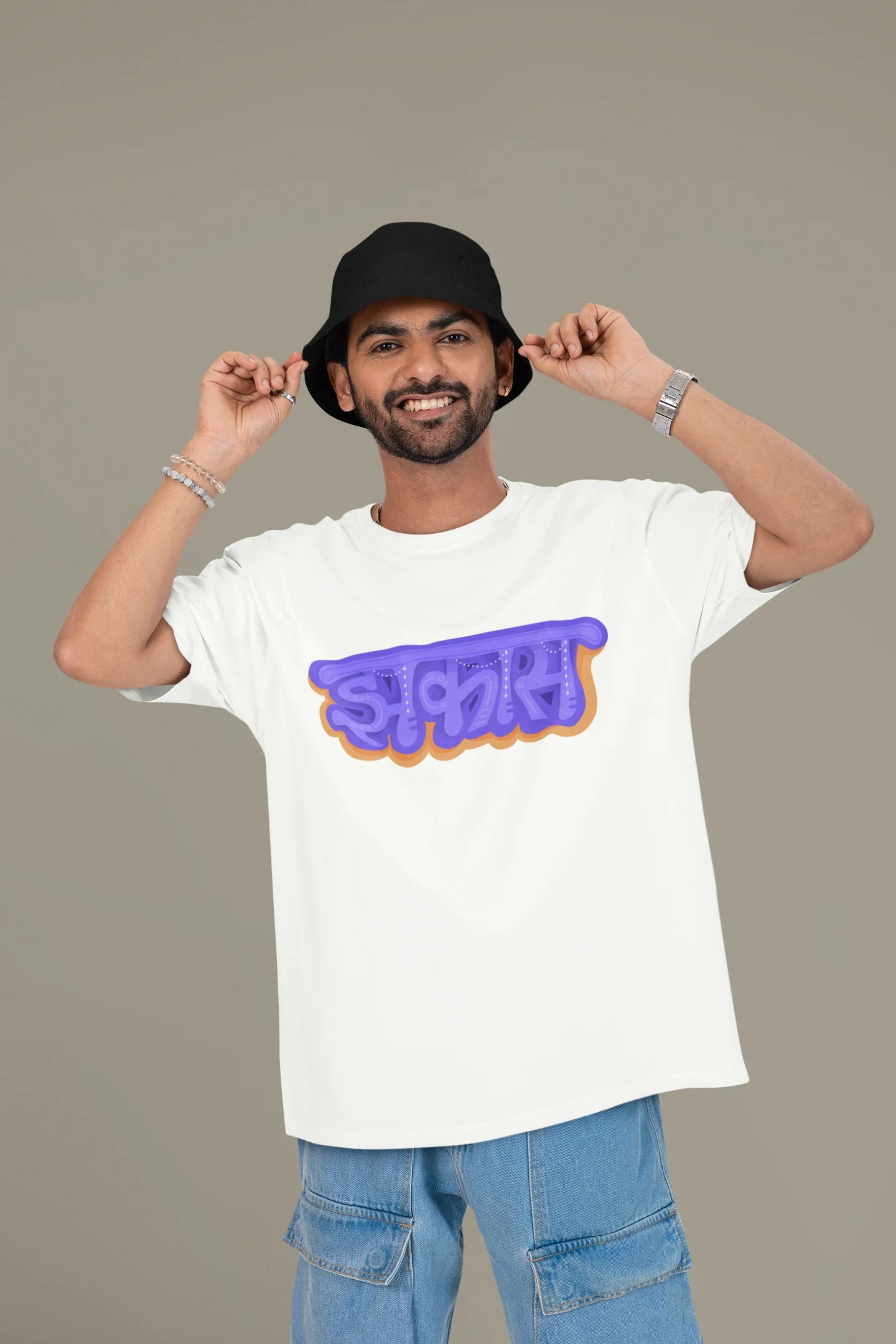 2nd front view of a male model wearing an off-white oversized t-shirt featuring "Jhakas" in a stylish font.
