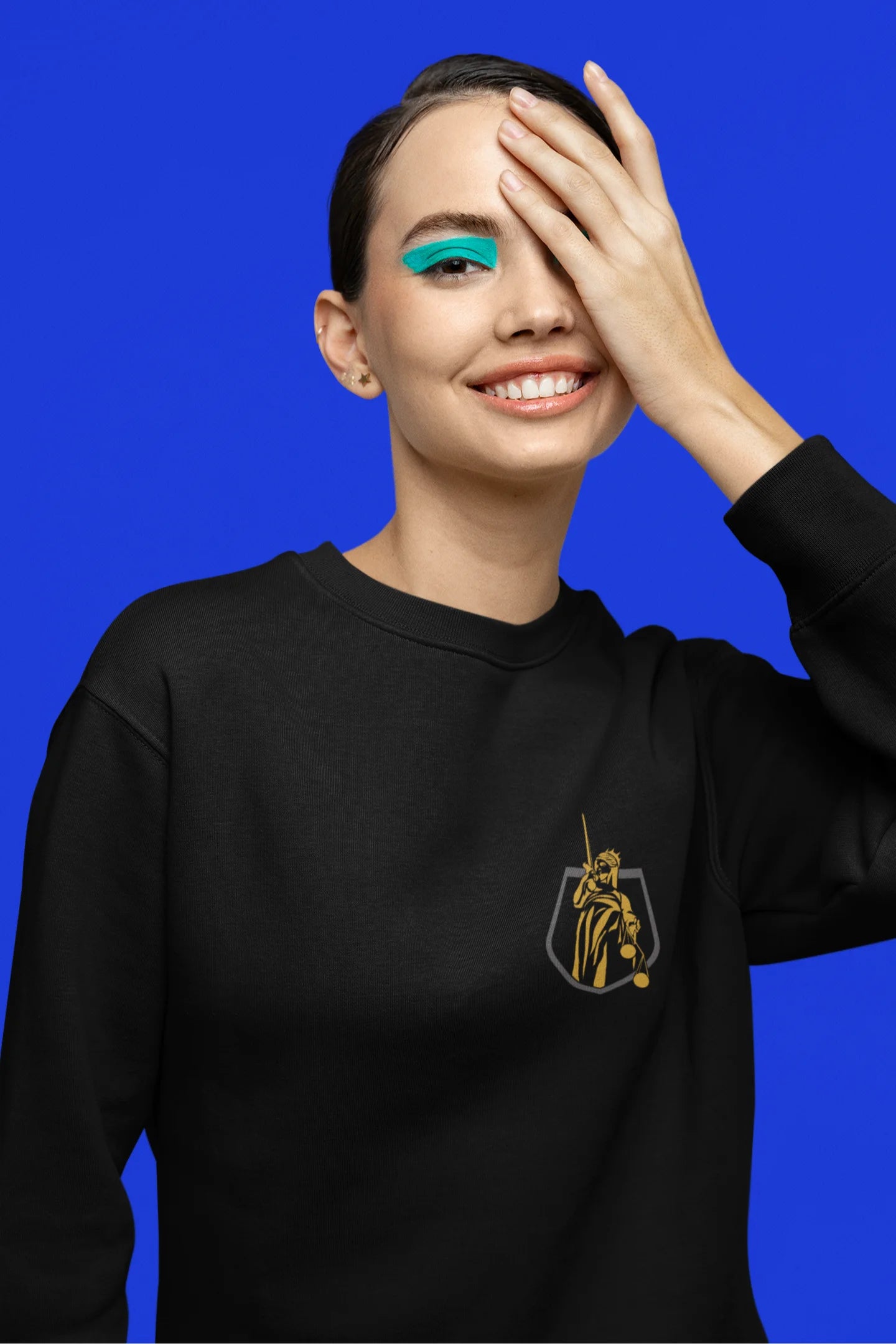 First front view of a female model wearing a black sweatshirt with a brutalist Lady Justice statue design.