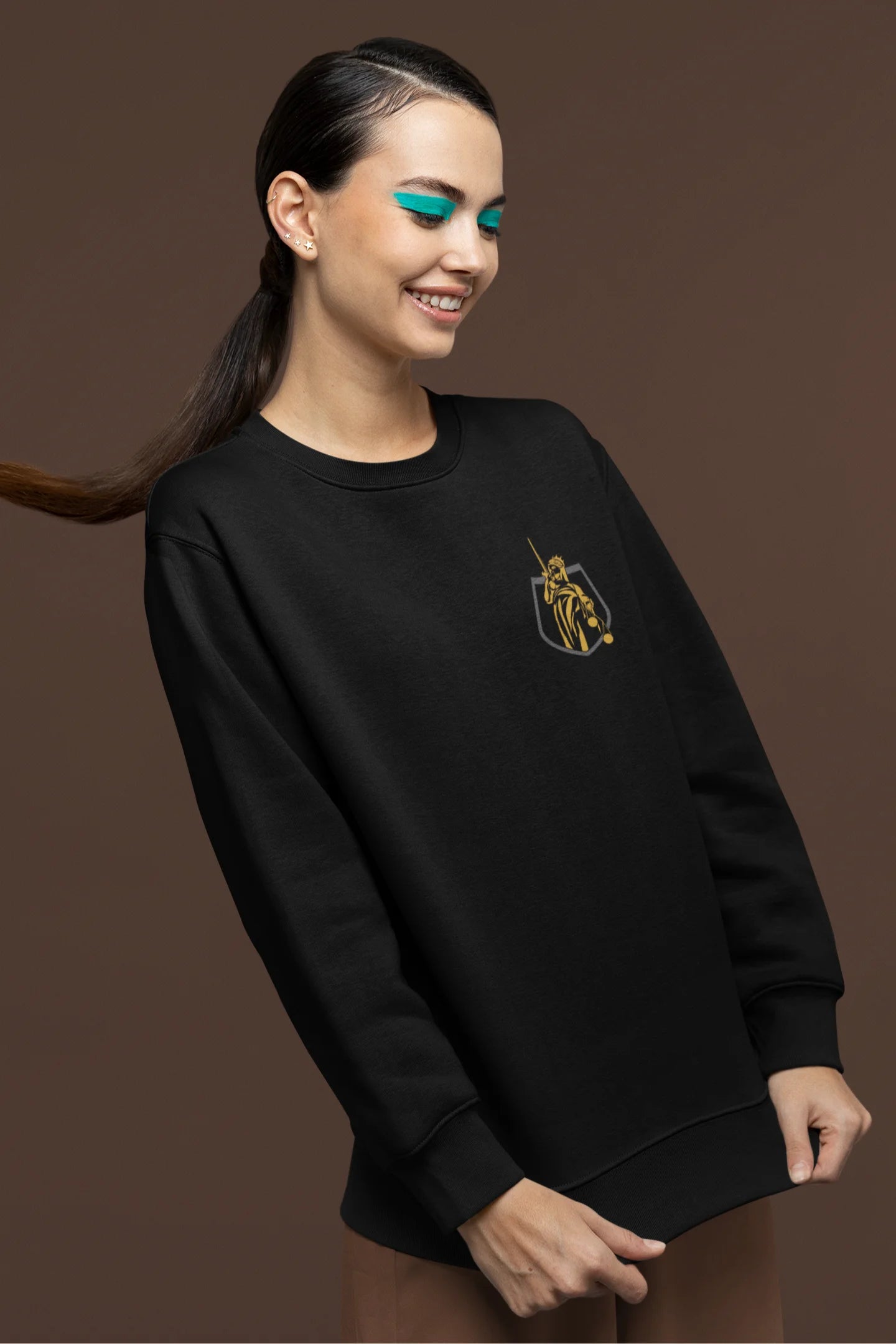 Side view of a female model wearing a black sweatshirt with a brutalist Lady Justice statue design.