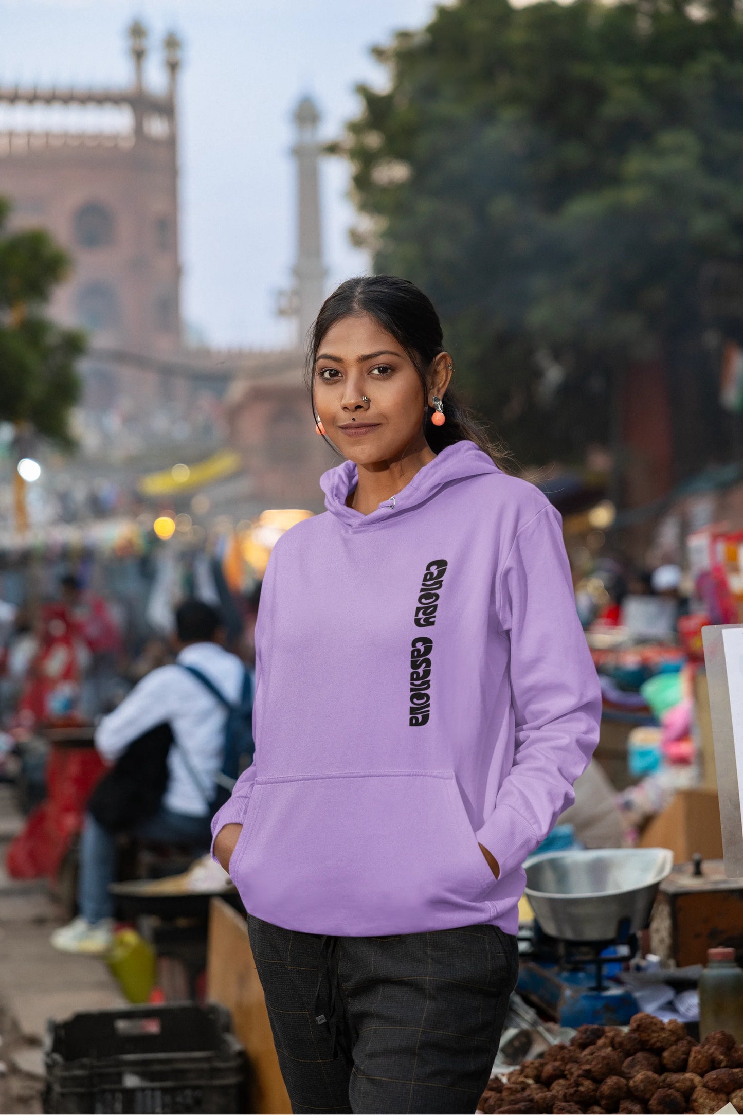 Sixth front view of a female model wearing a lavender hoodie with a toucan perched on a branch in a jungle setting.