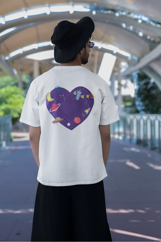 Back view of a male model wearing an white oversized t-shirt with the "Paradise" album artwork by Coldplay.