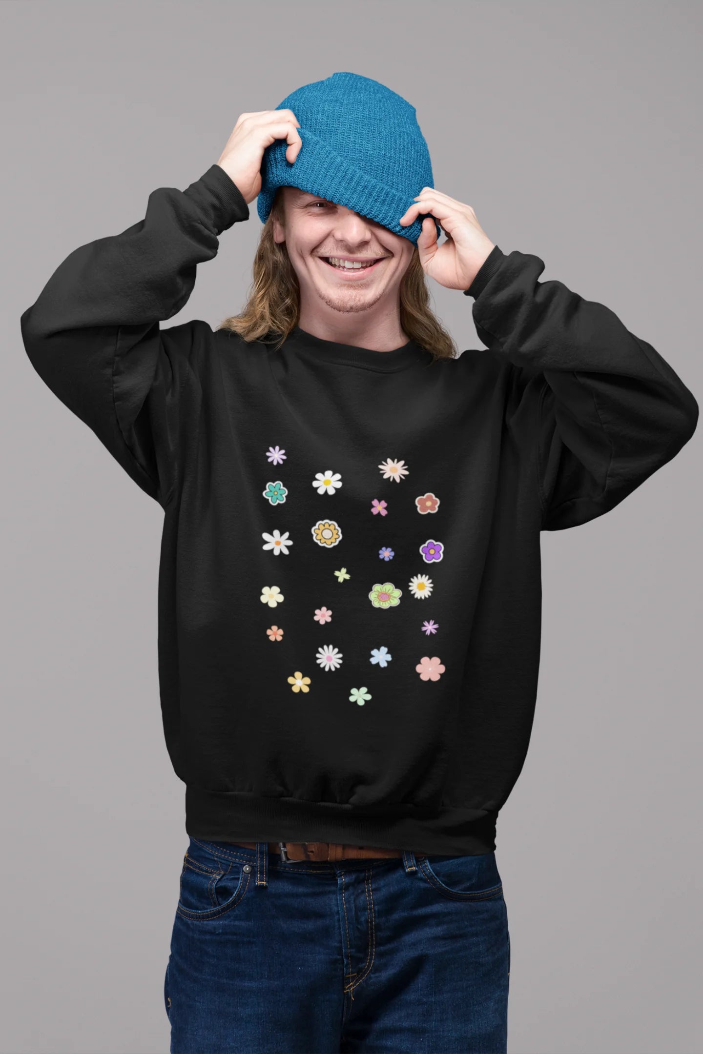 2nd front view of a male model wearing to a black sweatshirt featuring a vibrant floral design with roses, tulips, sunflowers, and orchids. Ideal for those who love floral patterns and spring fashion.