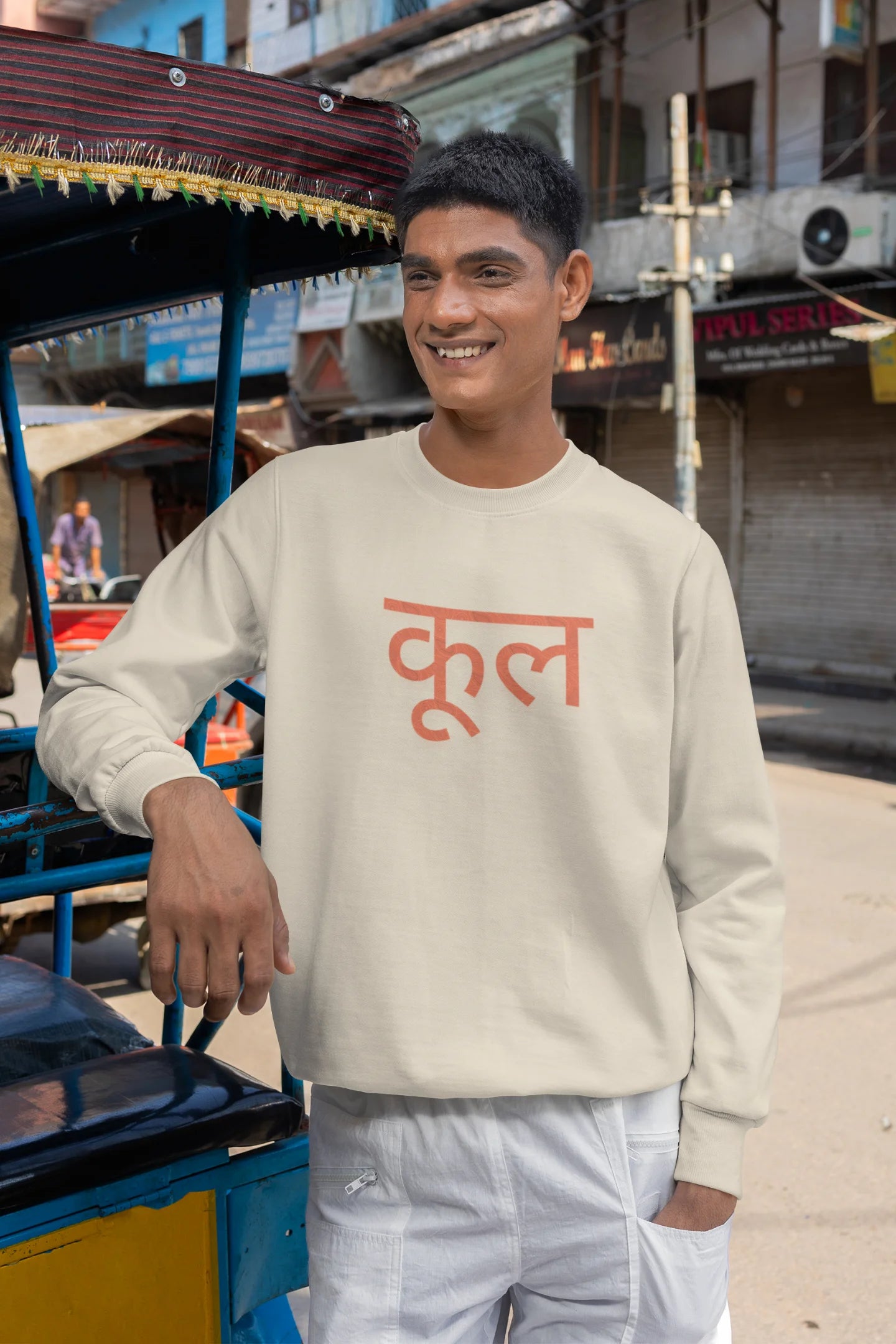 3rd front view of a male model wearing a cream oversized t-shirt featuring the Hindi word for "cool" with a unique, playful design.