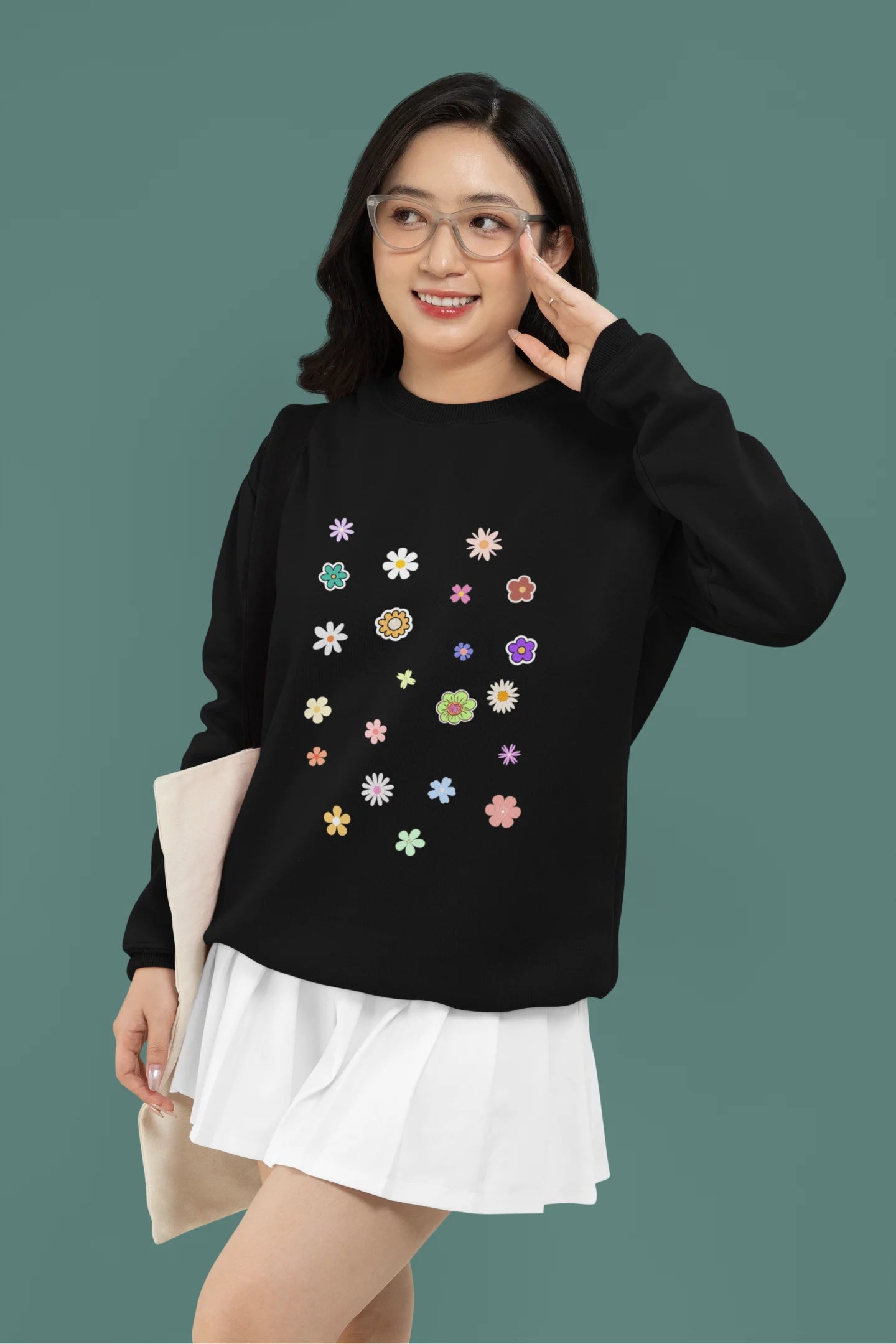 3rd front view of a female model wearing to a black sweatshirt featuring a vibrant floral design with roses, tulips, sunflowers, and orchids. Ideal for those who love floral patterns and spring fashion.