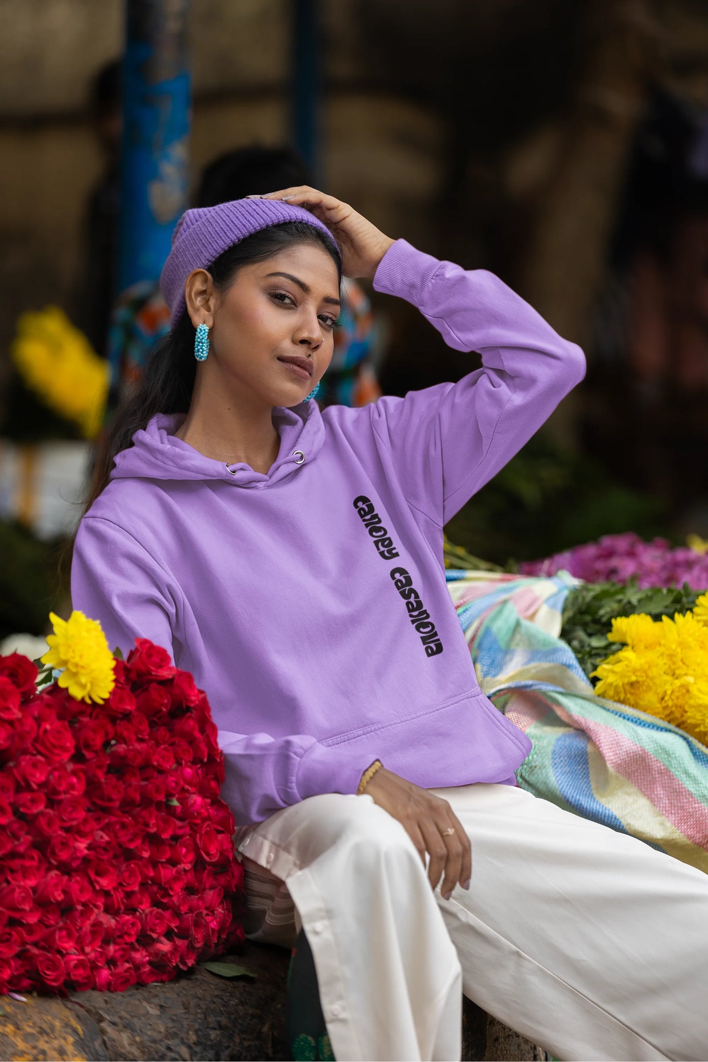 Fifth front view of a female model wearing a lavender hoodie with a toucan perched on a branch in a jungle setting.