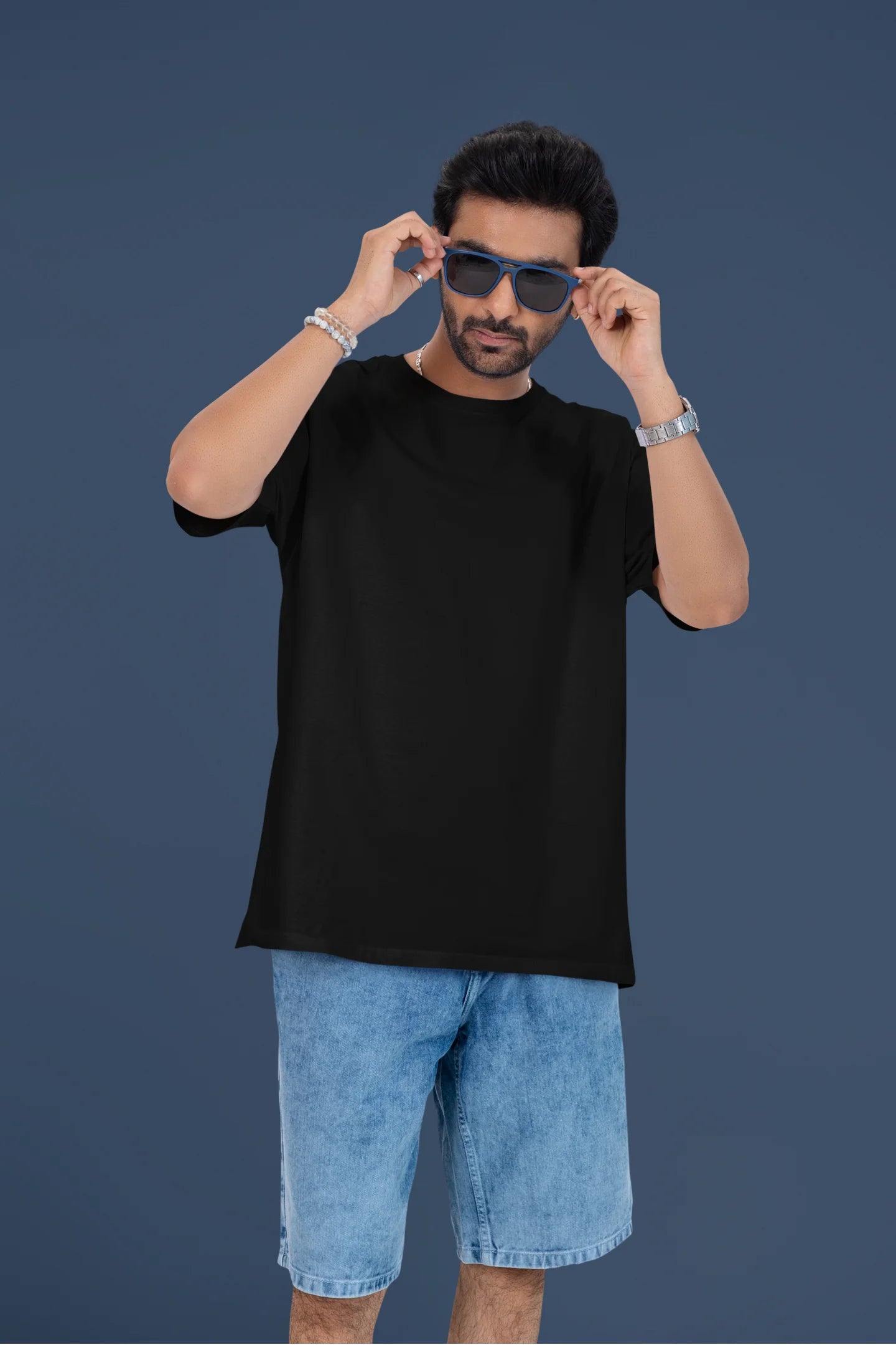 4th front view of a male model wearing a black oversized t-shirt featuring a couple dancing in the moonlight, inspired by Ed Sheeran's themes of love.