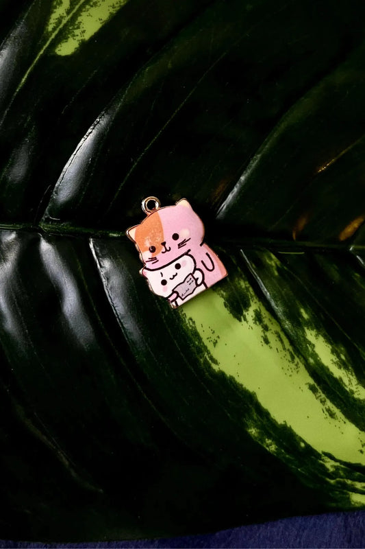 First view of a charm featuring a design of a mother cat and her kitten.