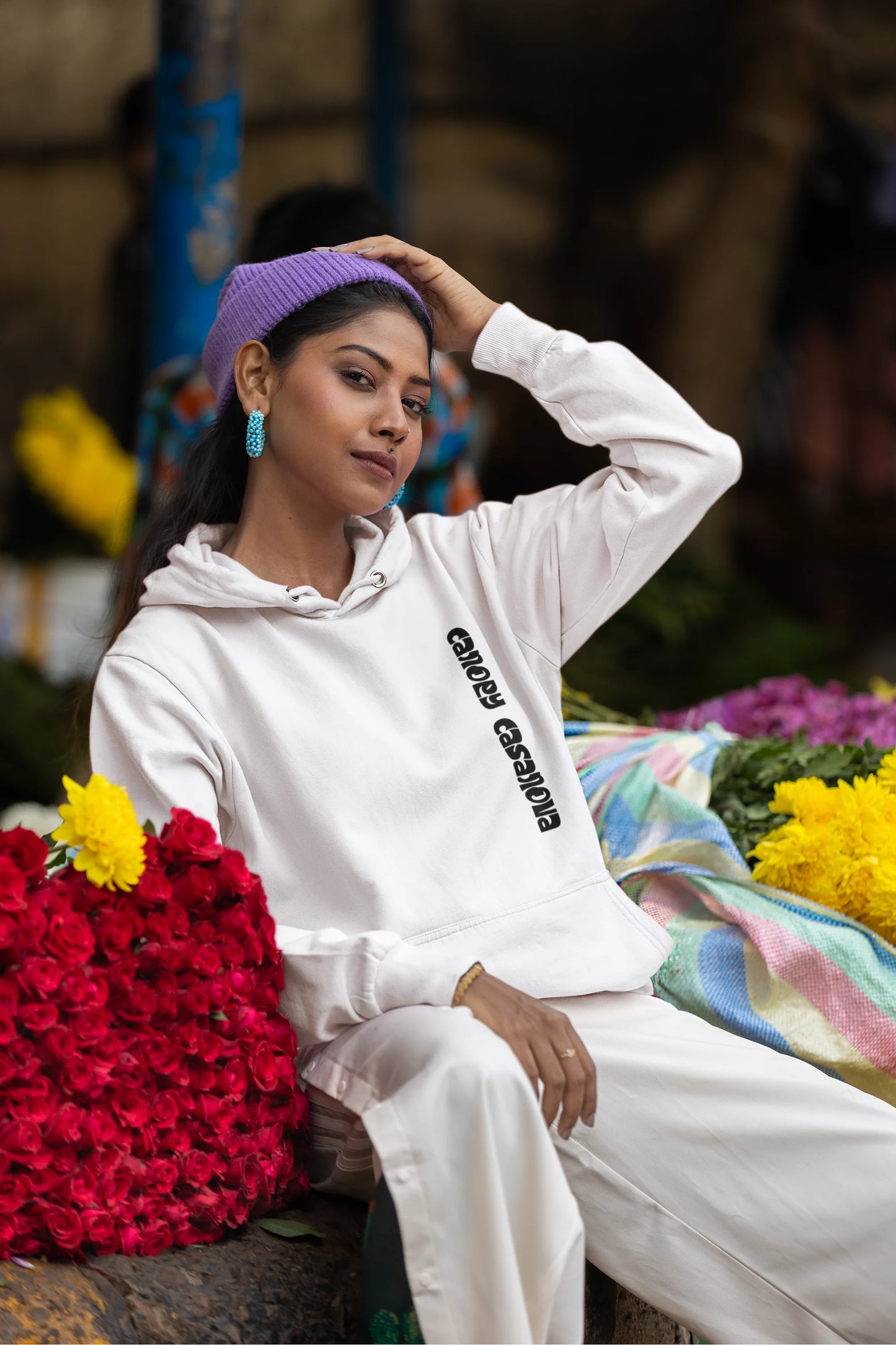 Fifth front view of a female model wearing a white hoodie with a toucan perched on a branch in a jungle setting.