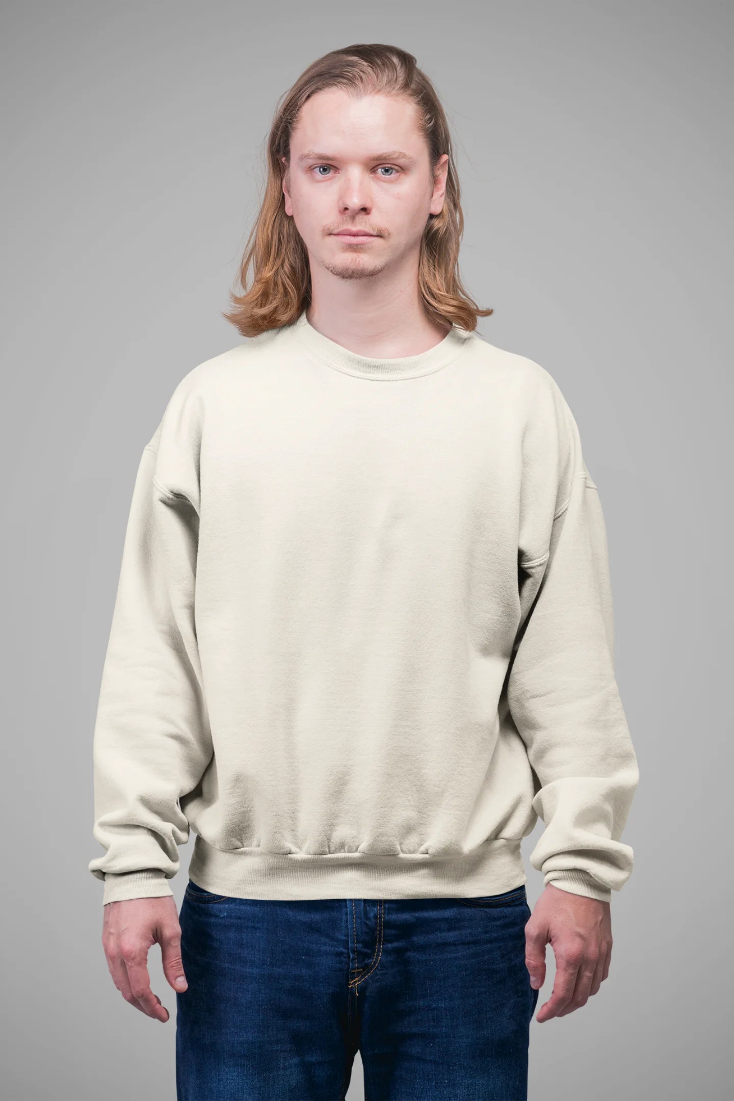 3rd front view of a male model wearing a cream sweatshirt featuring a nature-inspired design with a blue dragonfly perched on flowers amidst green grass. Ideal for those who love springtime aesthetics and dragonfly imagery.