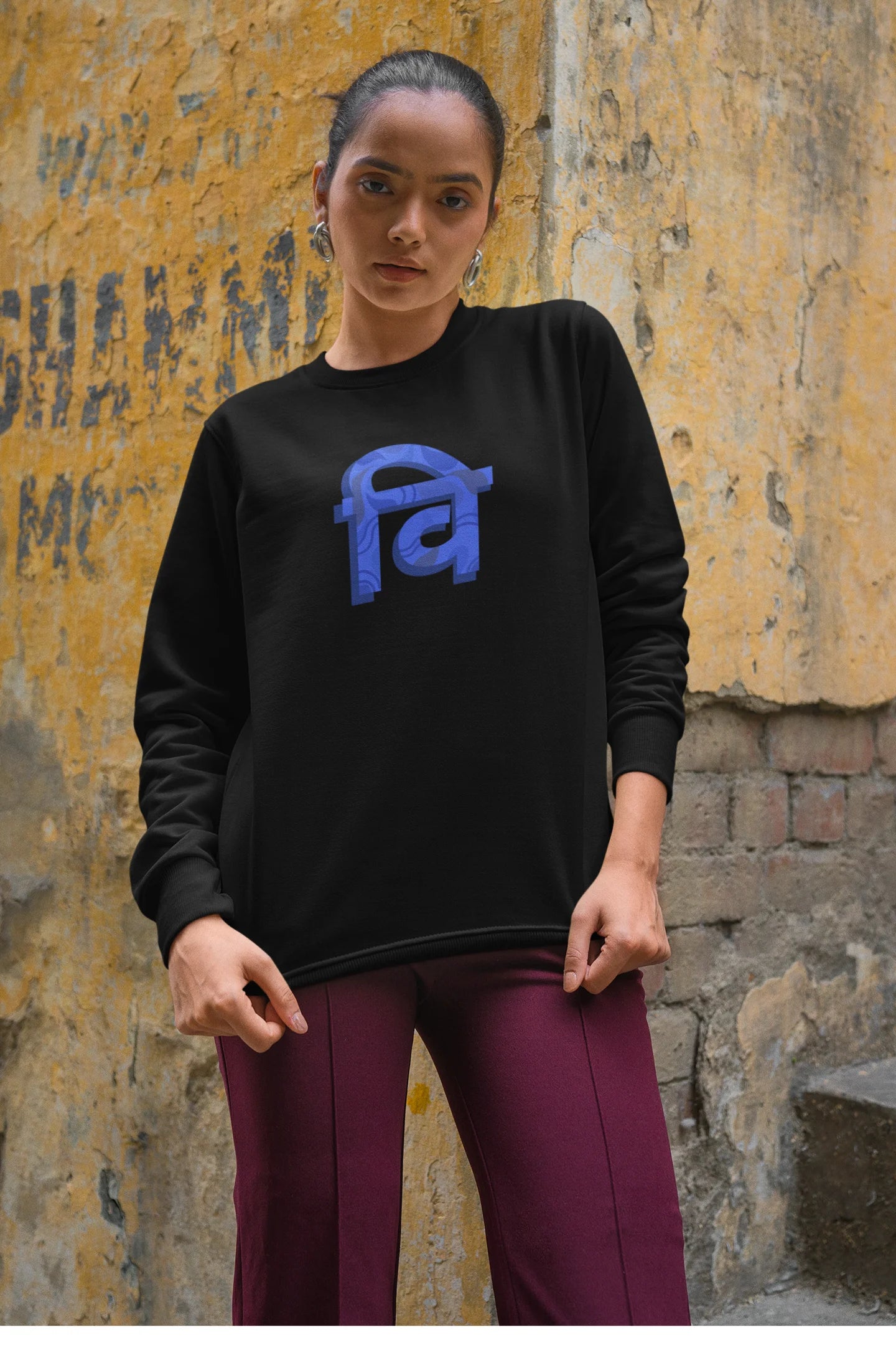 4th front view of a female model wearing a black sweatshirt with the phrase "Vichitra Pranee" (meaning "Strange being" or "alien") in a stylish Hindi font.