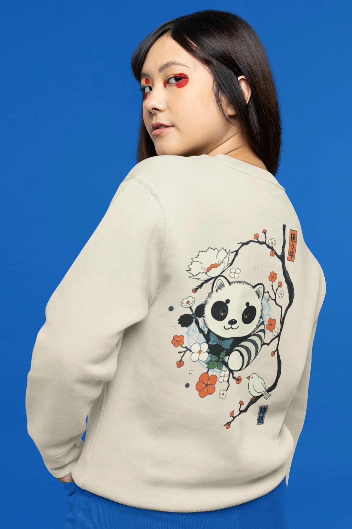 Back view of a female model wearing a cream sweatshirt with a panda fox surrounded by bamboo.