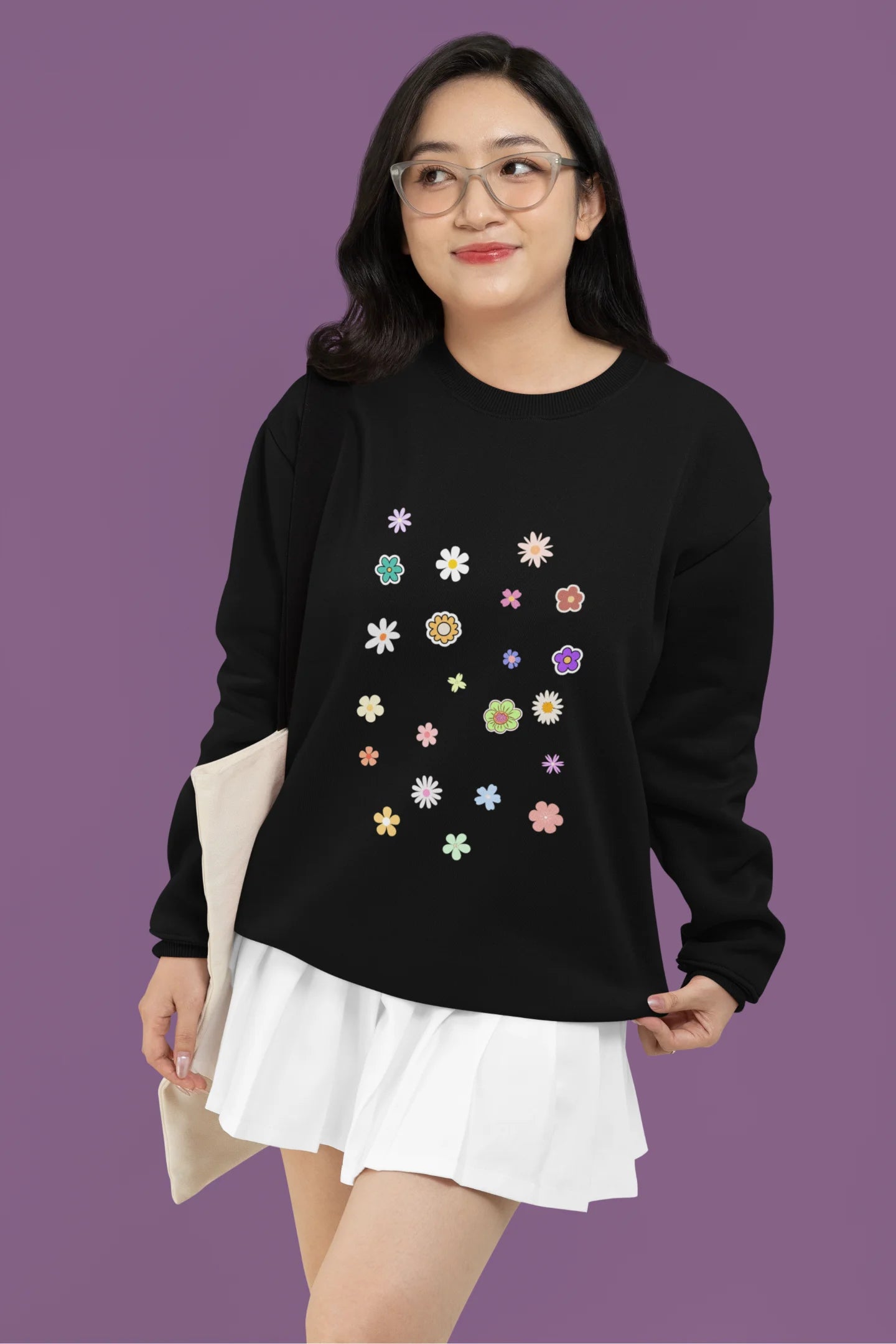 First front view of a female model wearing to a black sweatshirt featuring a vibrant floral design with roses, tulips, sunflowers, and orchids. Ideal for those who love floral patterns and spring fashion.