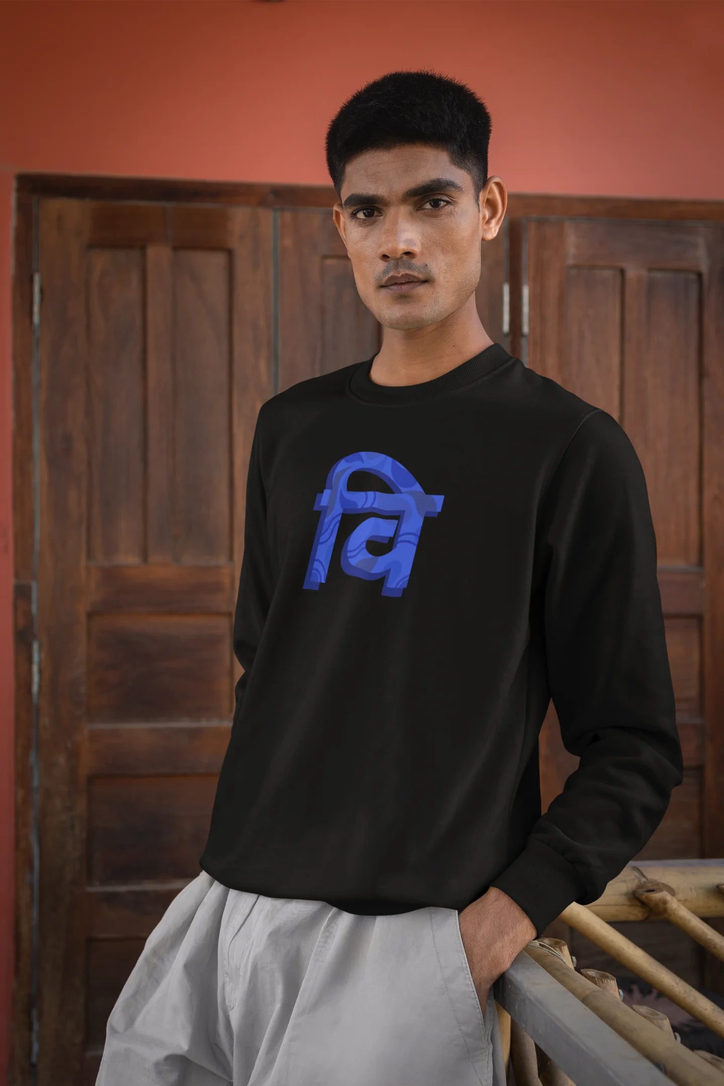 2nd front view of a male model wearing a black sweatshirt with the phrase "Vichitra Pranee" (meaning "Strange being" or "alien") in a stylish Hindi font.