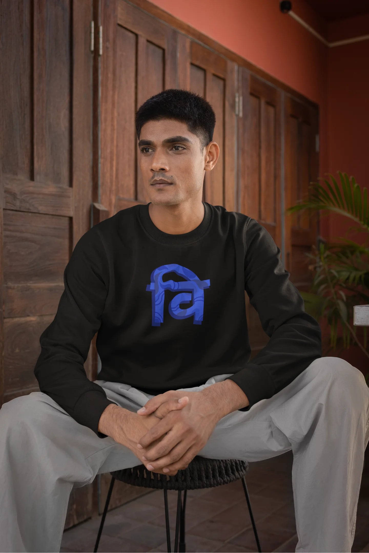 First front view of a male model wearing a black sweatshirt with the phrase "Vichitra Pranee" (meaning "Strange being" or "alien") in a stylish Hindi font.