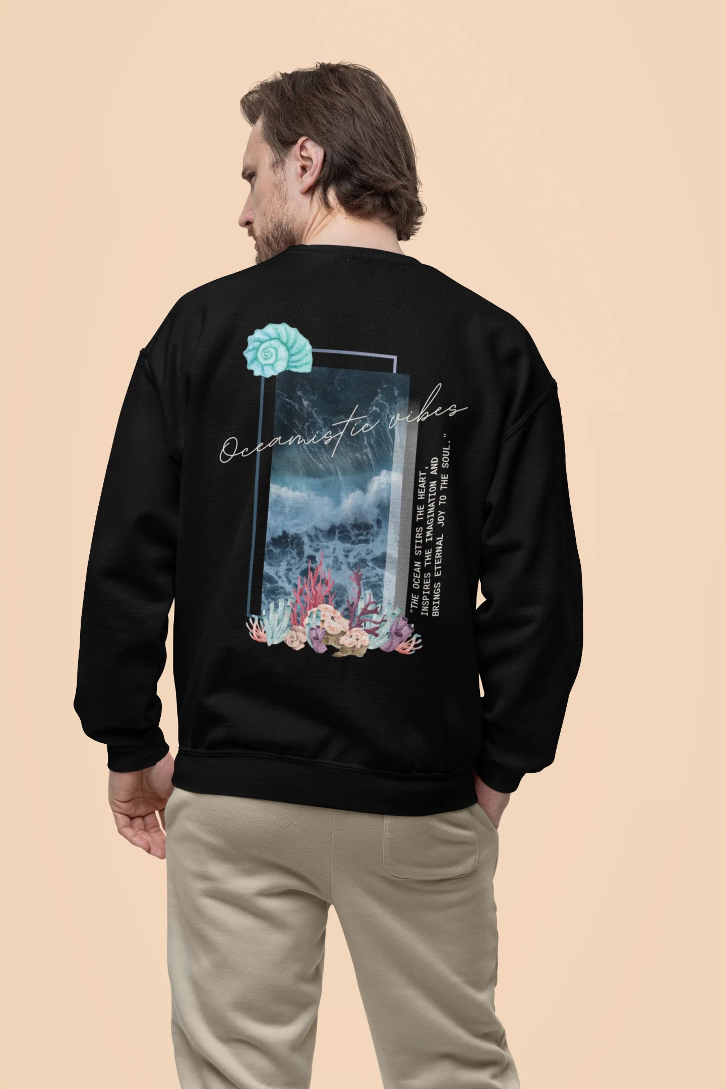 Back view of a male model wearing a black sweatshirt featuring a stunning design of corals and shells, evoking a serene underwater atmosphere.