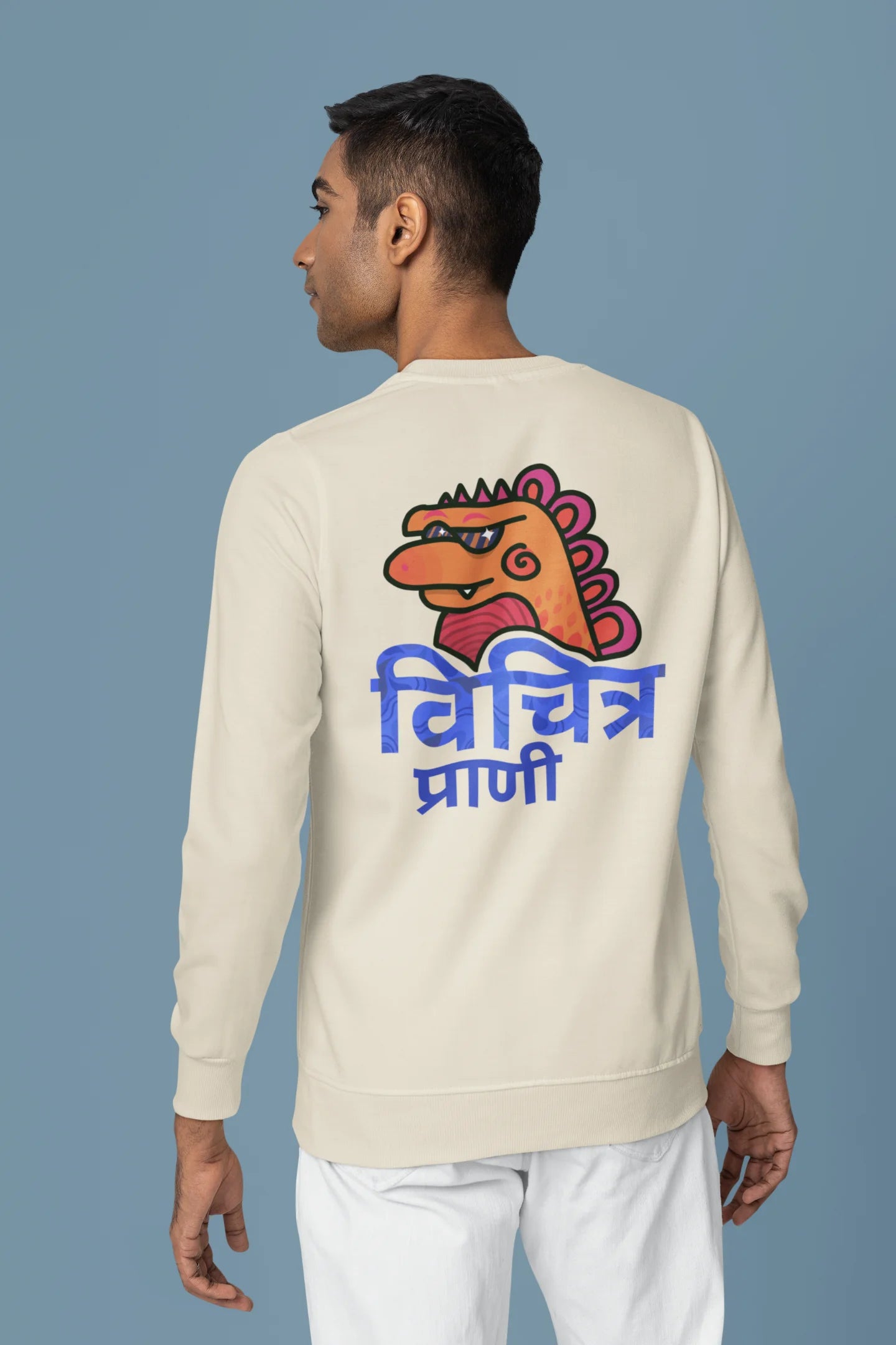 Back view of a male model wearing a cream sweatshirt with the phrase "Vichitra Pranee" (meaning "Strange being" or "alien") in a stylish Hindi font.