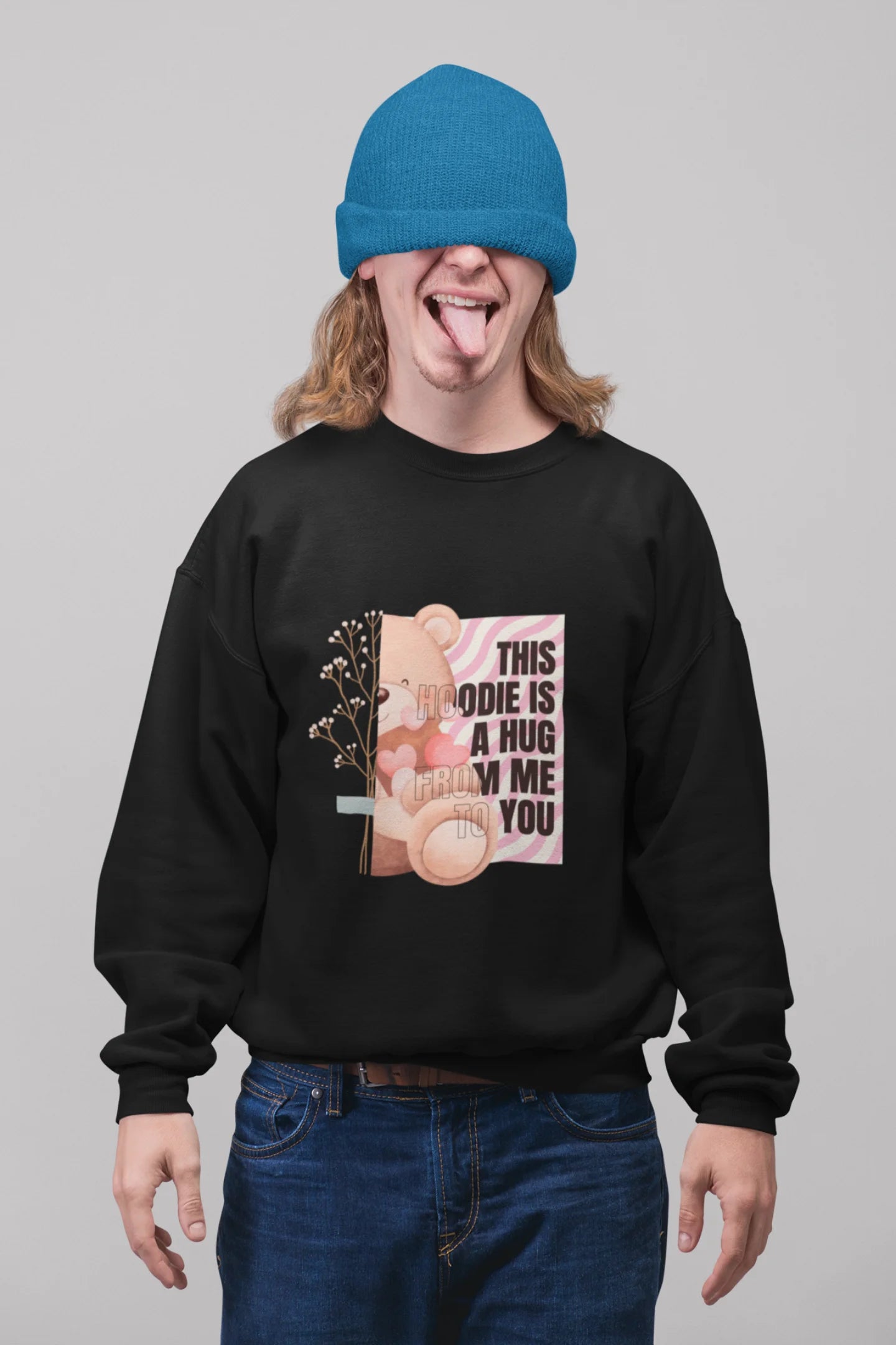 First front view of a male model wearing a black sweatshirt with a heartwarming design of a teddy bear offering a hug, offering a comforting and relaxing aesthetic.