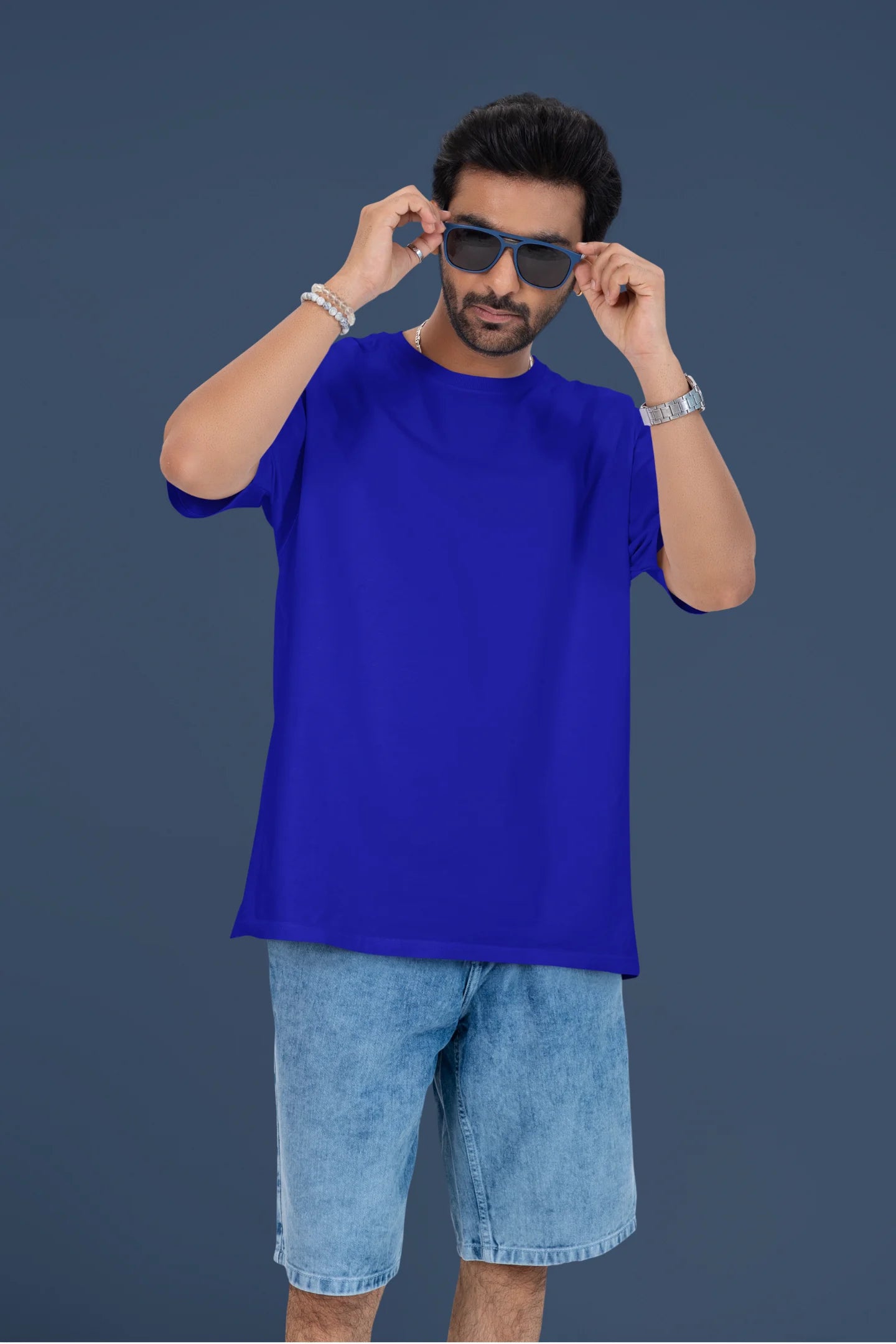 4th front view of a male model wearing a royal blue oversized t-shirt featuring a couple dancing in the moonlight, inspired by Ed Sheeran's themes of love.
