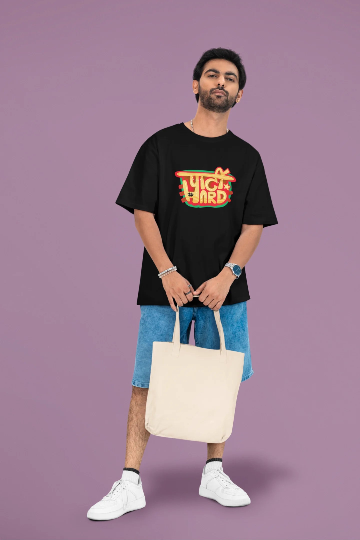 2nd front view of a male model wearing a black oversized t-shirt with the phrase "Party Hard" in an energetic Hindi.