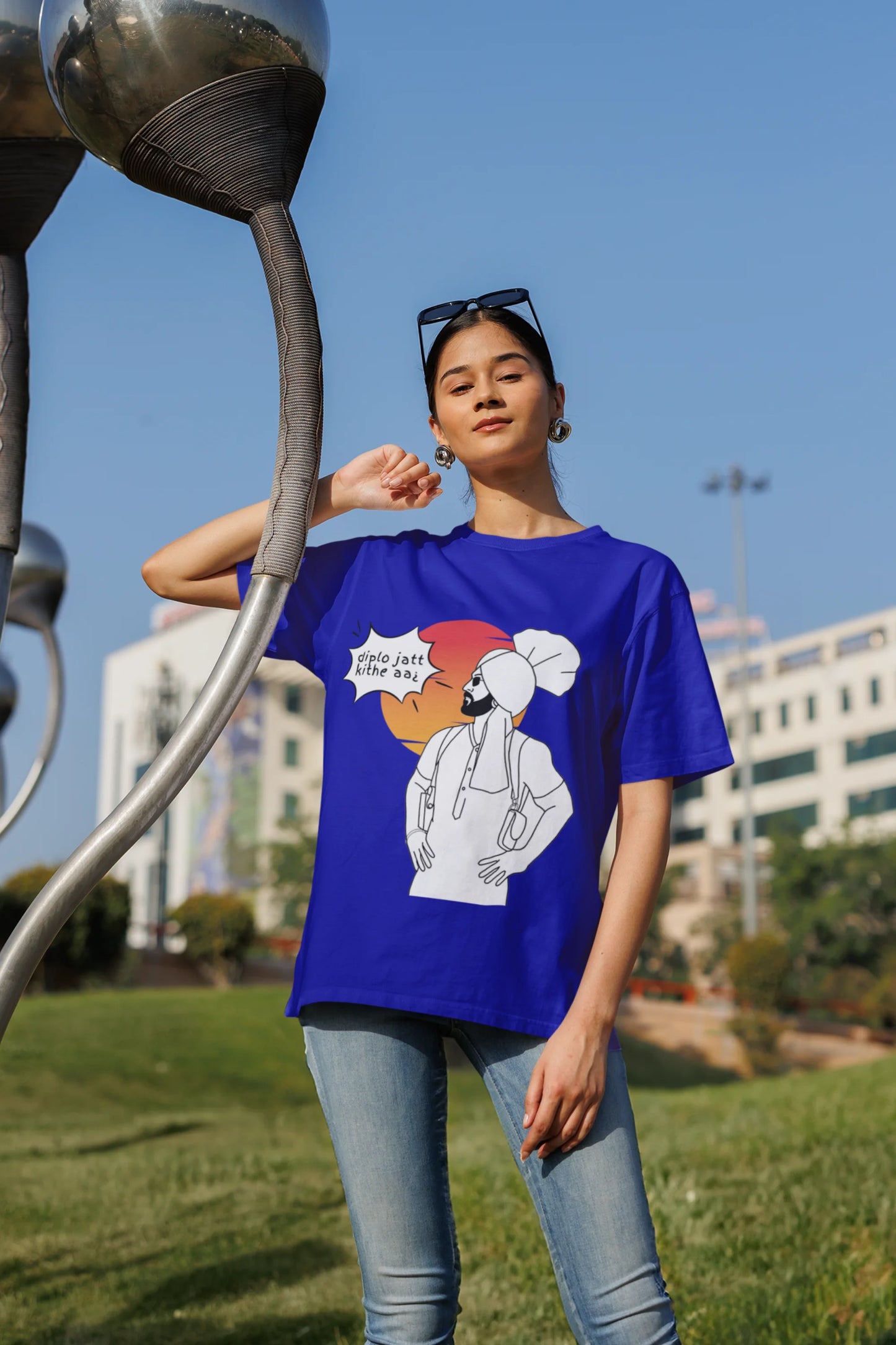Fourth image of a female model wearing a royal blue oversized tshirt with a A portrait of Diljit Dosanjh wearing a stylish outfit, with the text "Diplo Jatt Kithe Aai" prominently displayed in the background. The design captures the artist's charisma and the energy of the hit song, making it a must-have for fans of Diljit Dosanjh and Diplo alike.