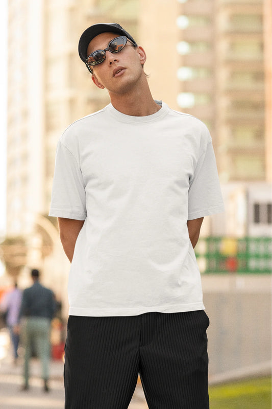 Front view of man wearing white Oversize T-shirt featuring Taylor Swift Midnight design on the back of it.