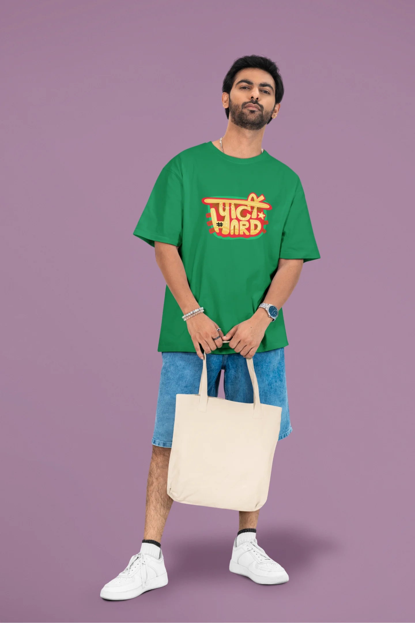 3rd front view of a male model wearing a forest green oversized t-shirt with the phrase "Party Hard" in an energetic Hindi.