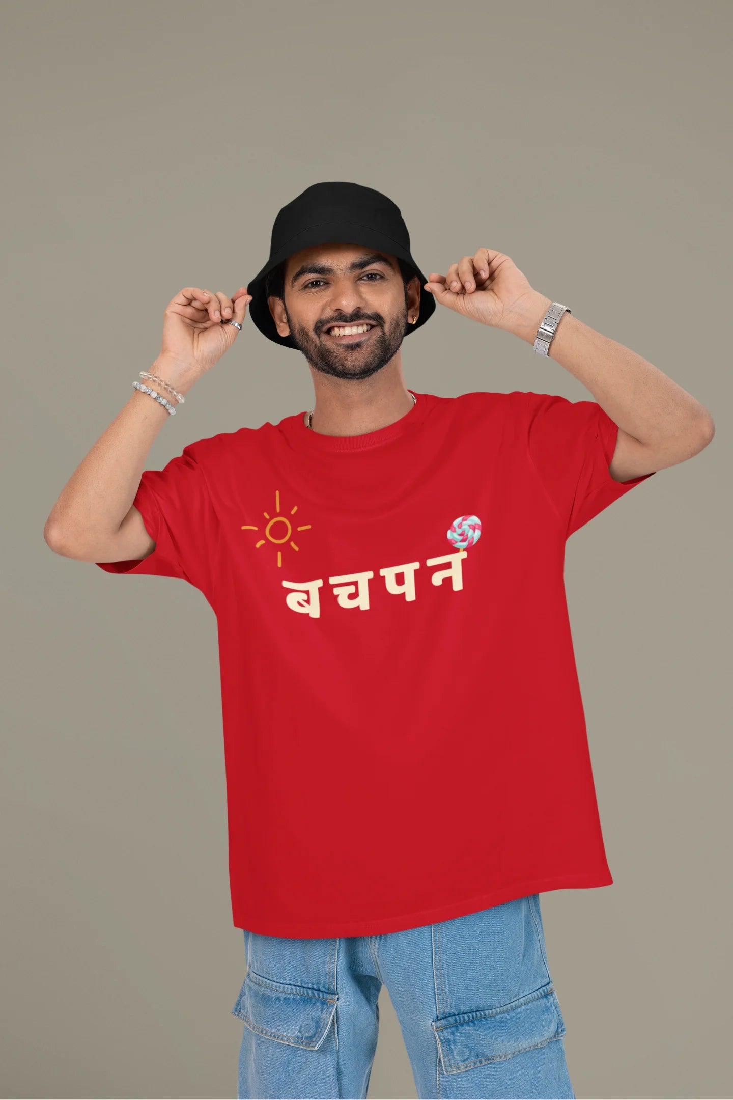 First front view of a male model wearing a red oversized t-shirt with a design representing "Bachpan" (childhood) and the concept of "Khatta Mitha" (sweet and sour).