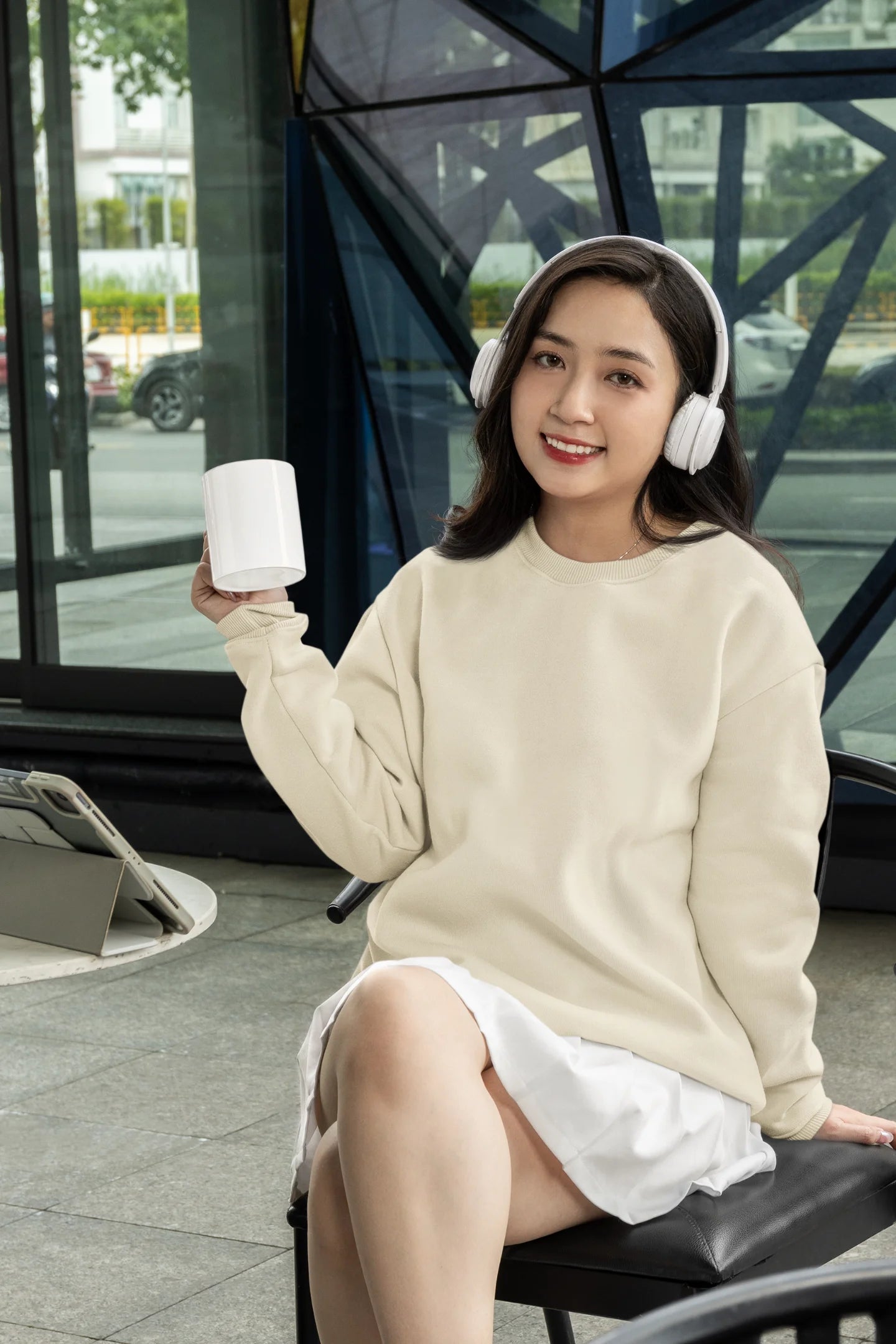 2nd front view of female model wearing an cream sweatshirt featuring a thought-provoking design of a golden lock shaped like an insect. Ideal for those who love symbolic clothing and unique conversation starters.