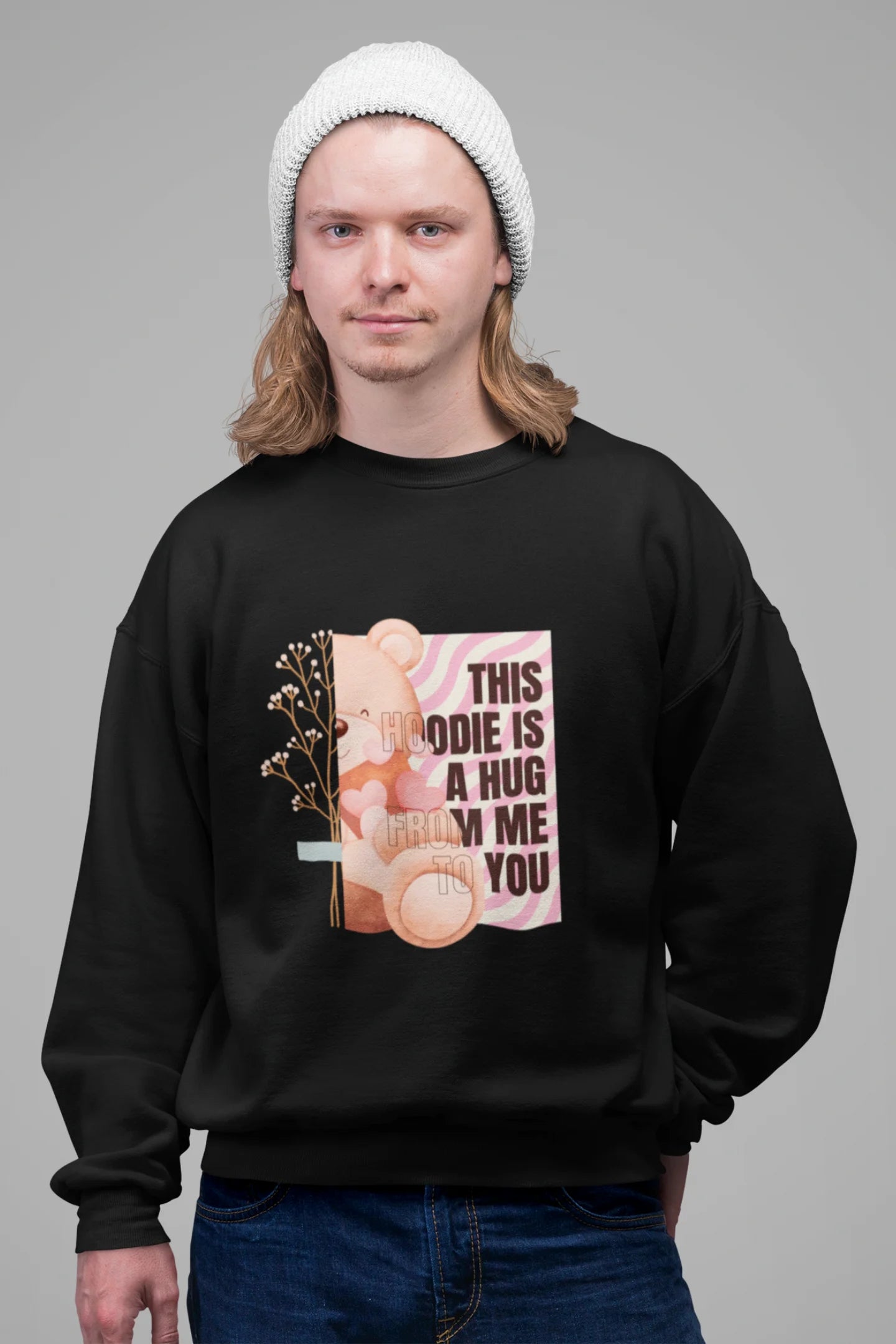 3rd front view of a male model wearing a black sweatshirt with a heartwarming design of a teddy bear offering a hug, offering a comforting and relaxing aesthetic.