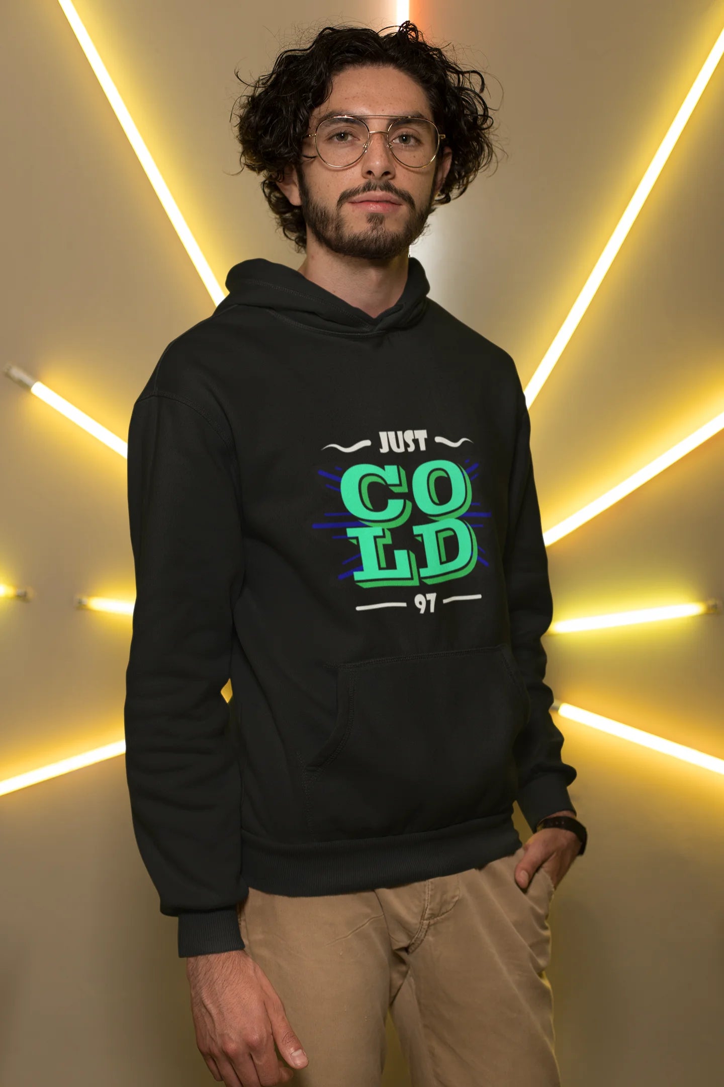 First front view of a male model wearing an black sweatshirt with the text "Just Cold" printed on it.