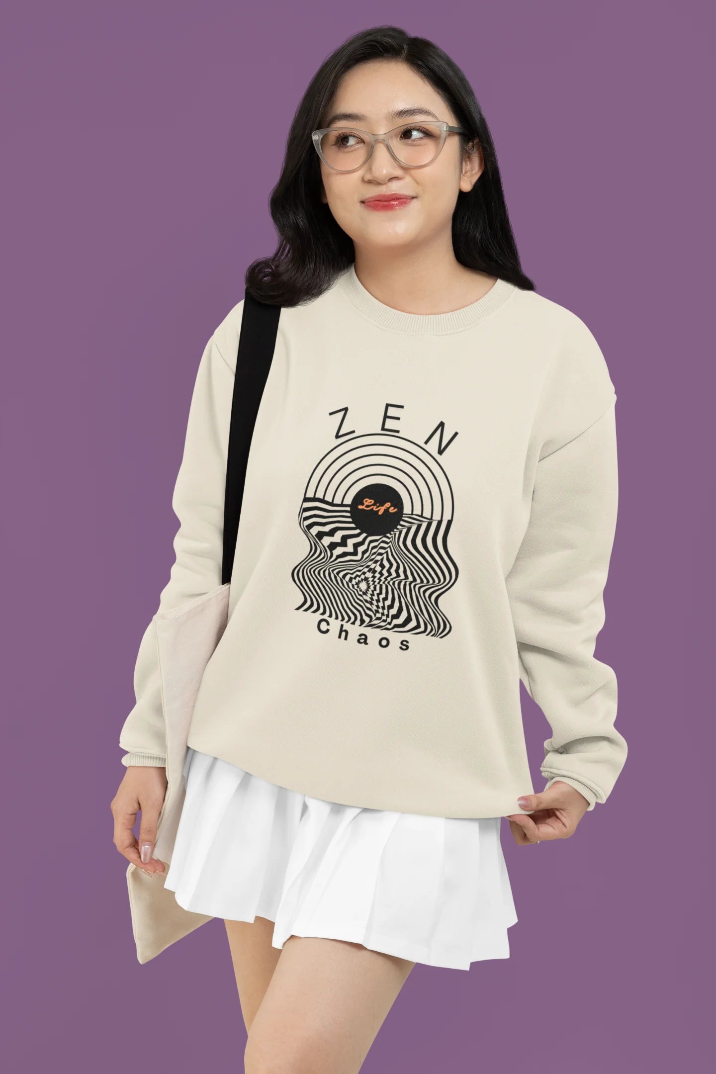 4th front view of a female model wearing an cream sweatshirt featuring an aesthetic design of a setting sun and crashing waves with the text "Zen & Chaos" above it. Ideal for those who love philosophical themes and visually striking clothing.