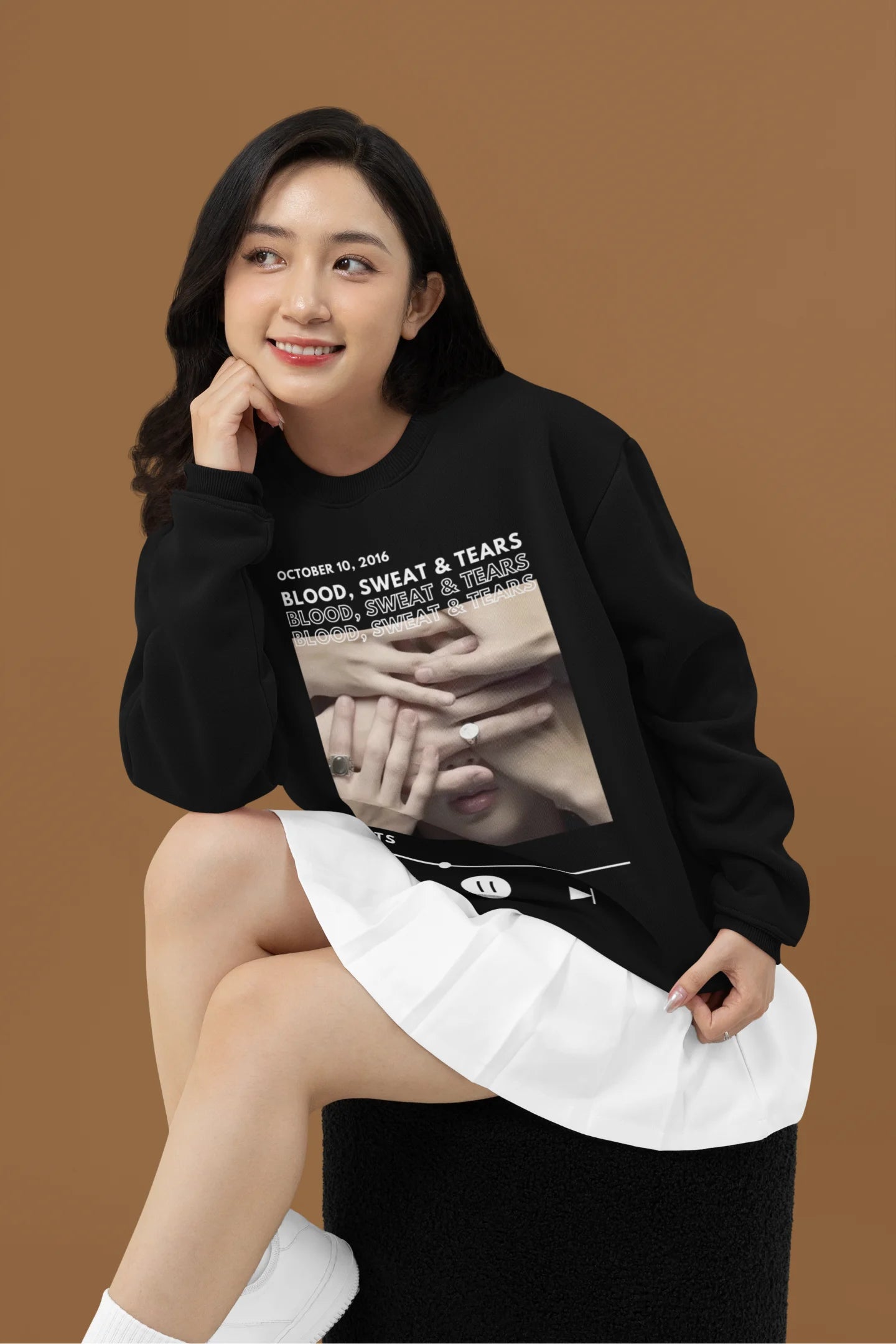 Second front view of a female model wearing a black sweatshirt featuring a design inspired by BTS's music video "Blood, Sweat & Tears." Ideal for BTS fans (ARMY) who want to celebrate this iconic era.