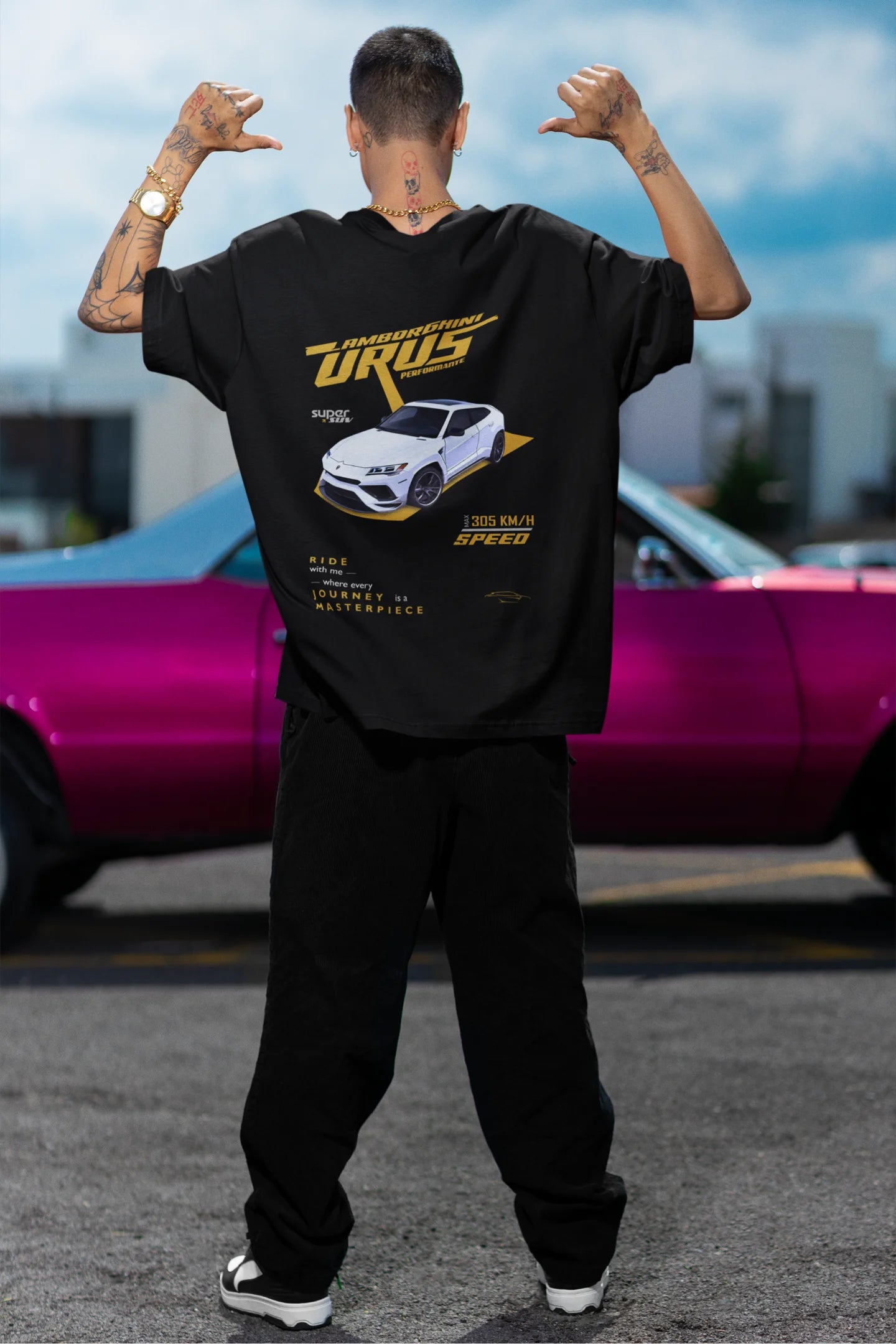 Back view of a male model wearing a black oversized t-shirt featuring a design of a Lamborghini Urus.