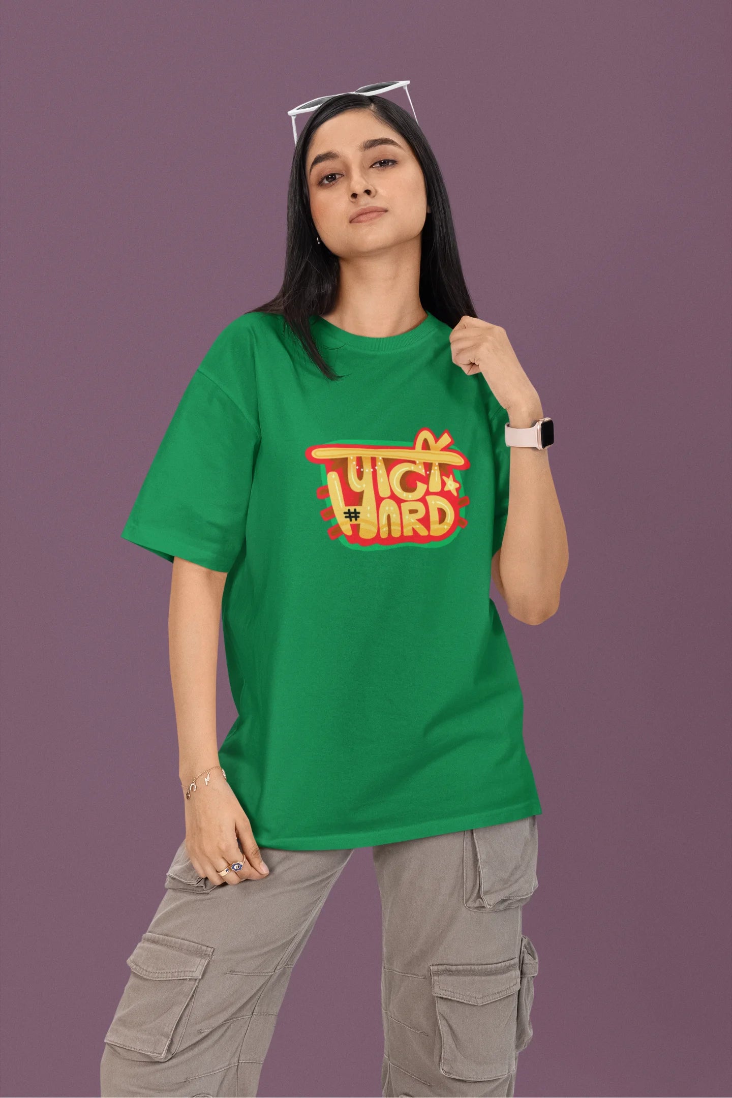 2nd front view of a female model wearing a forest green oversized t-shirt with the phrase "Party Hard" in an energetic Hindi.