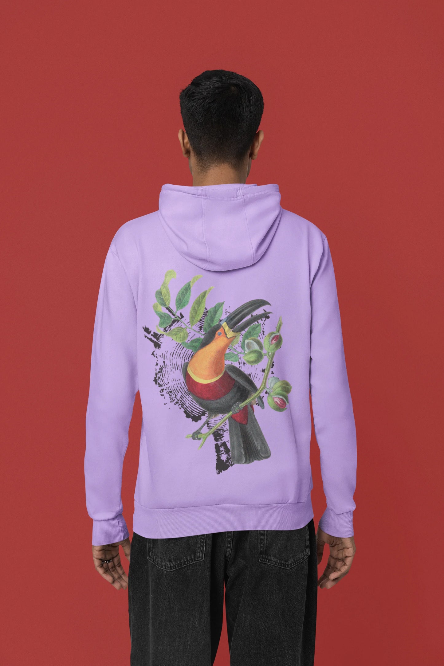 Back view of a male model wearing a lavender hoodie with a toucan perched on a branch in a jungle setting.