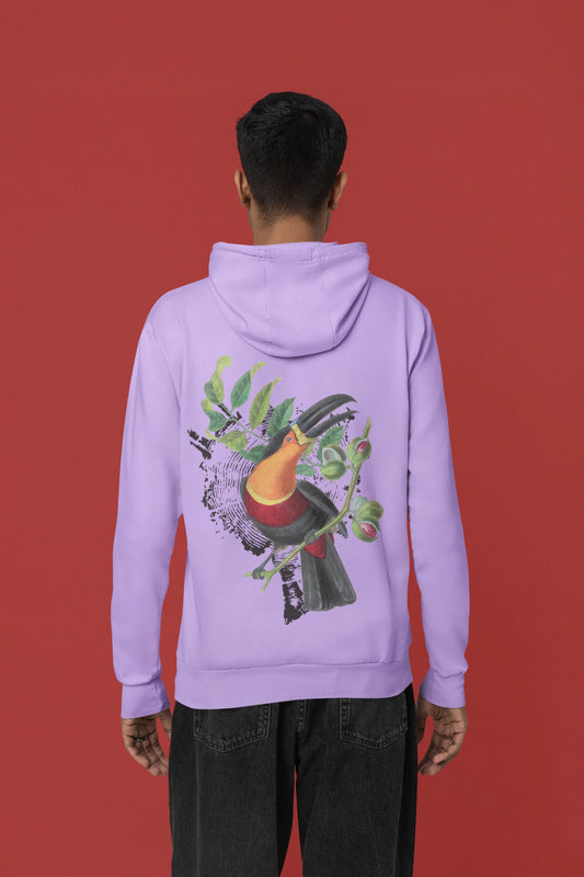 Back view of a male model wearing a lavender hoodie with a toucan perched on a branch in a jungle setting.
