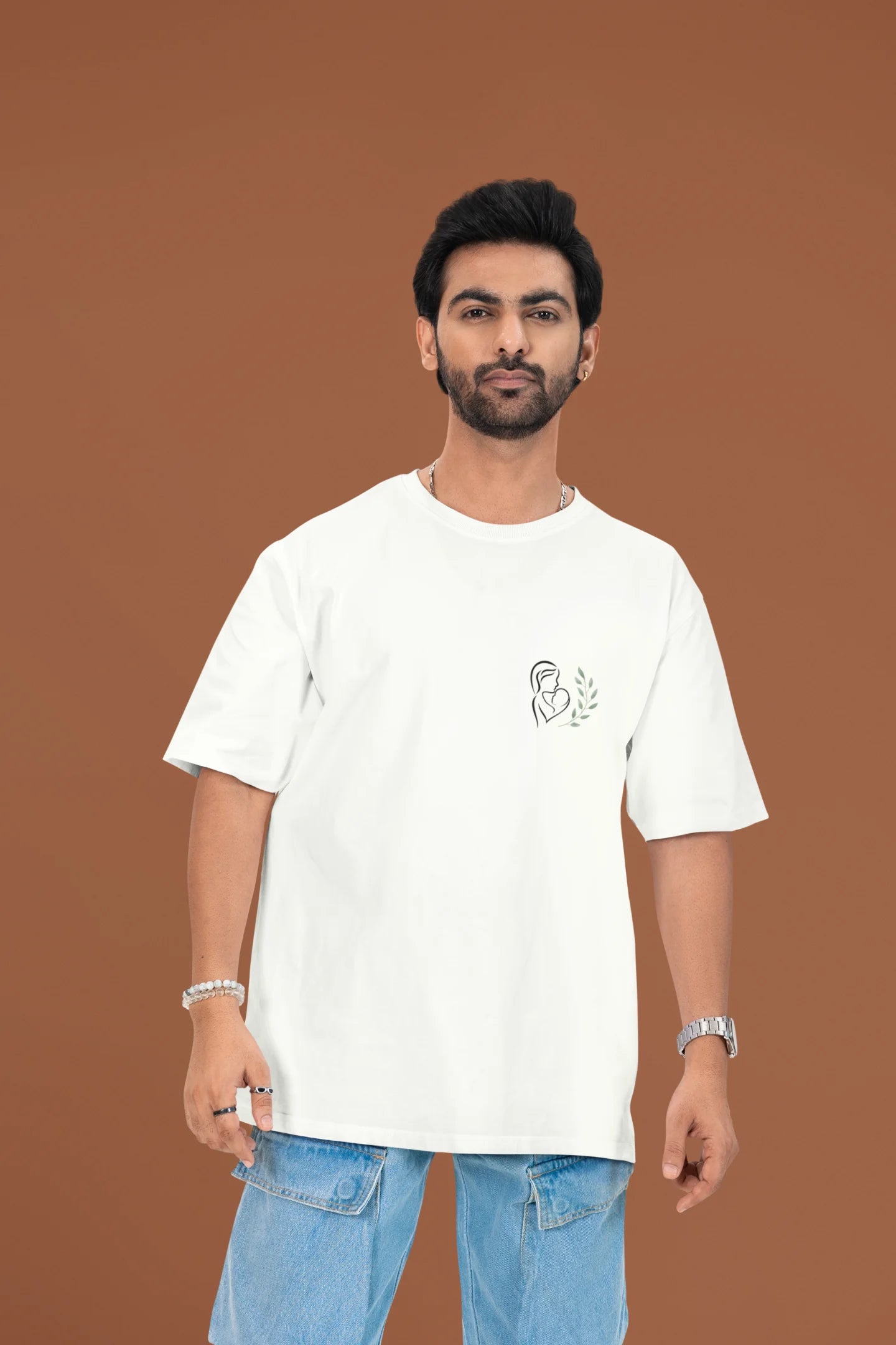 Front view of a male model wearing an off-white oversized t-shirt featuring a design depicting a mother tenderly holding a baby