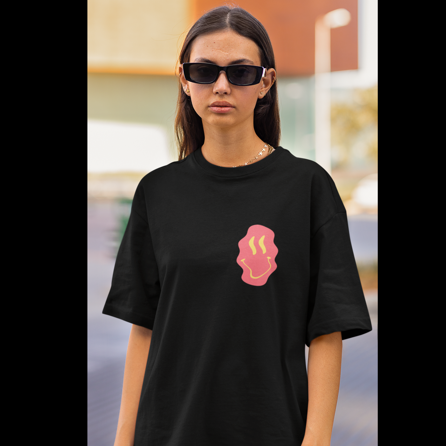Front view of a female model wearing a black oversized t-shirt featuring a fun "Space Wreck" design with elements of spaceships, UFOs, and a hint of extraterrestrial life.