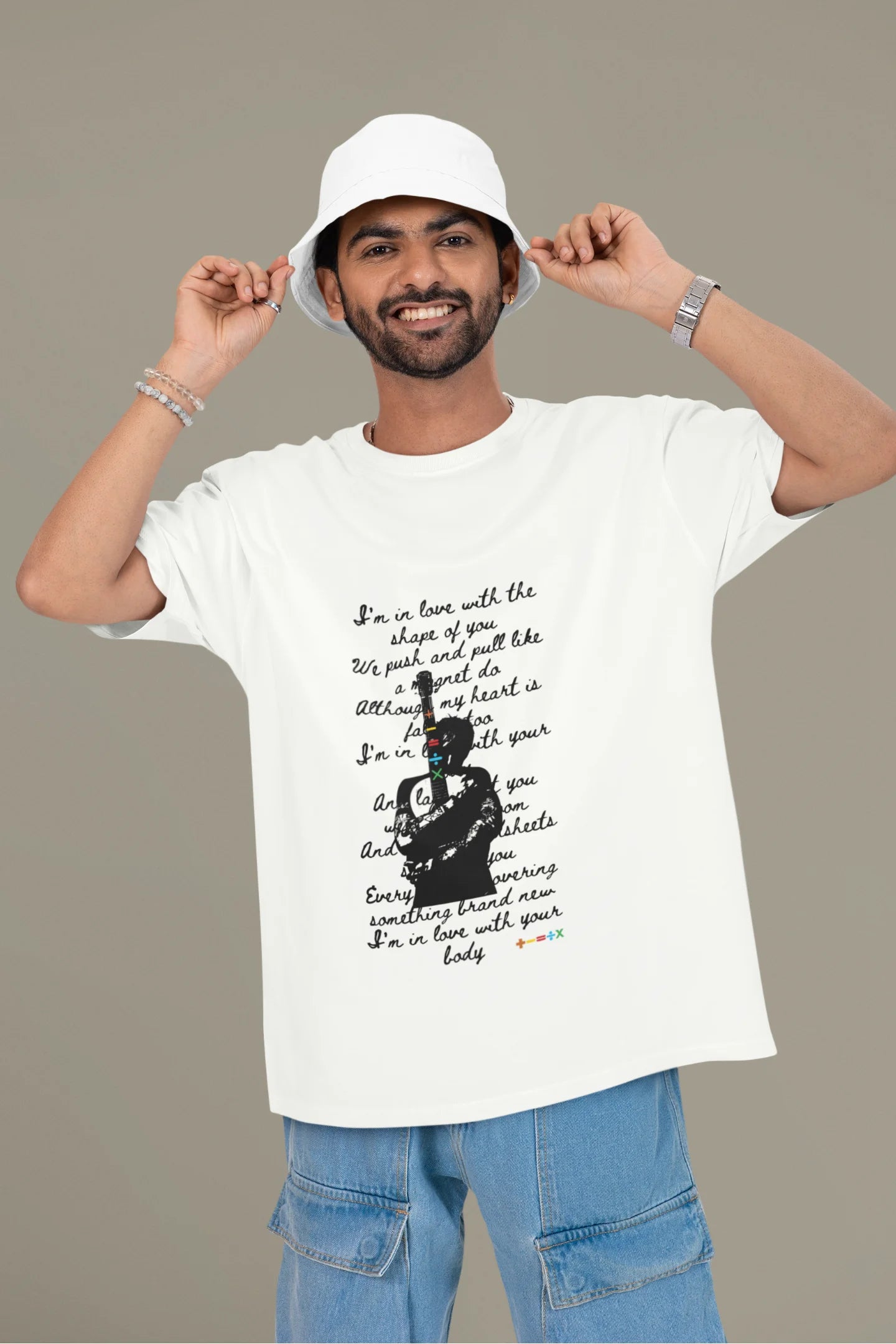 First front view of a male model wearing a off-white oversized t-shirt featuring a design inspired by Ed Sheeran's concerts, related to the song "Shape of You."