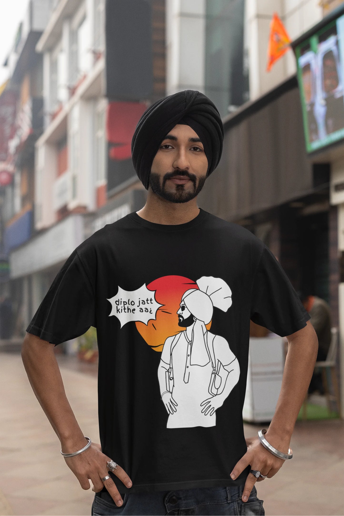 Third image of a male model wearing a black oversized tshirt with a A portrait of Diljit Dosanjh wearing a stylish outfit, with the text "Diplo Jatt Kithe Aai" prominently displayed in the background. The design captures the artist's charisma and the energy of the hit song, making it a must-have for fans of Diljit Dosanjh and Diplo alike.