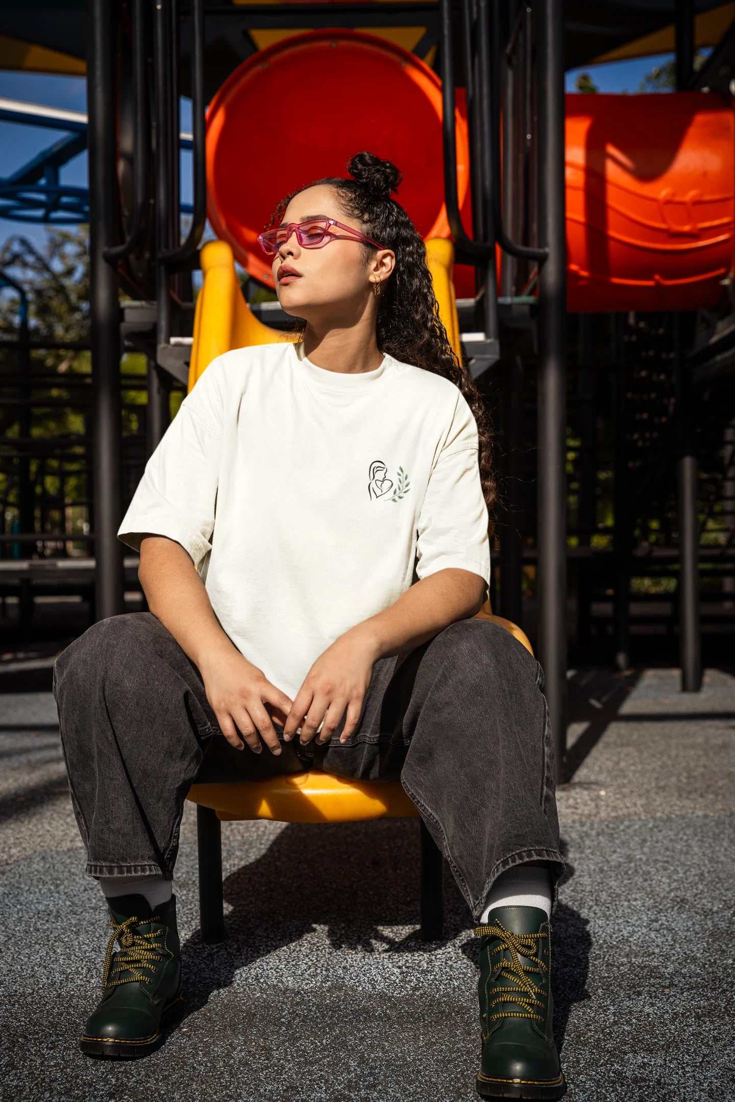 Side view of a female model wearing an off-white oversized t-shirt featuring a design depicting a mother tenderly holding a baby