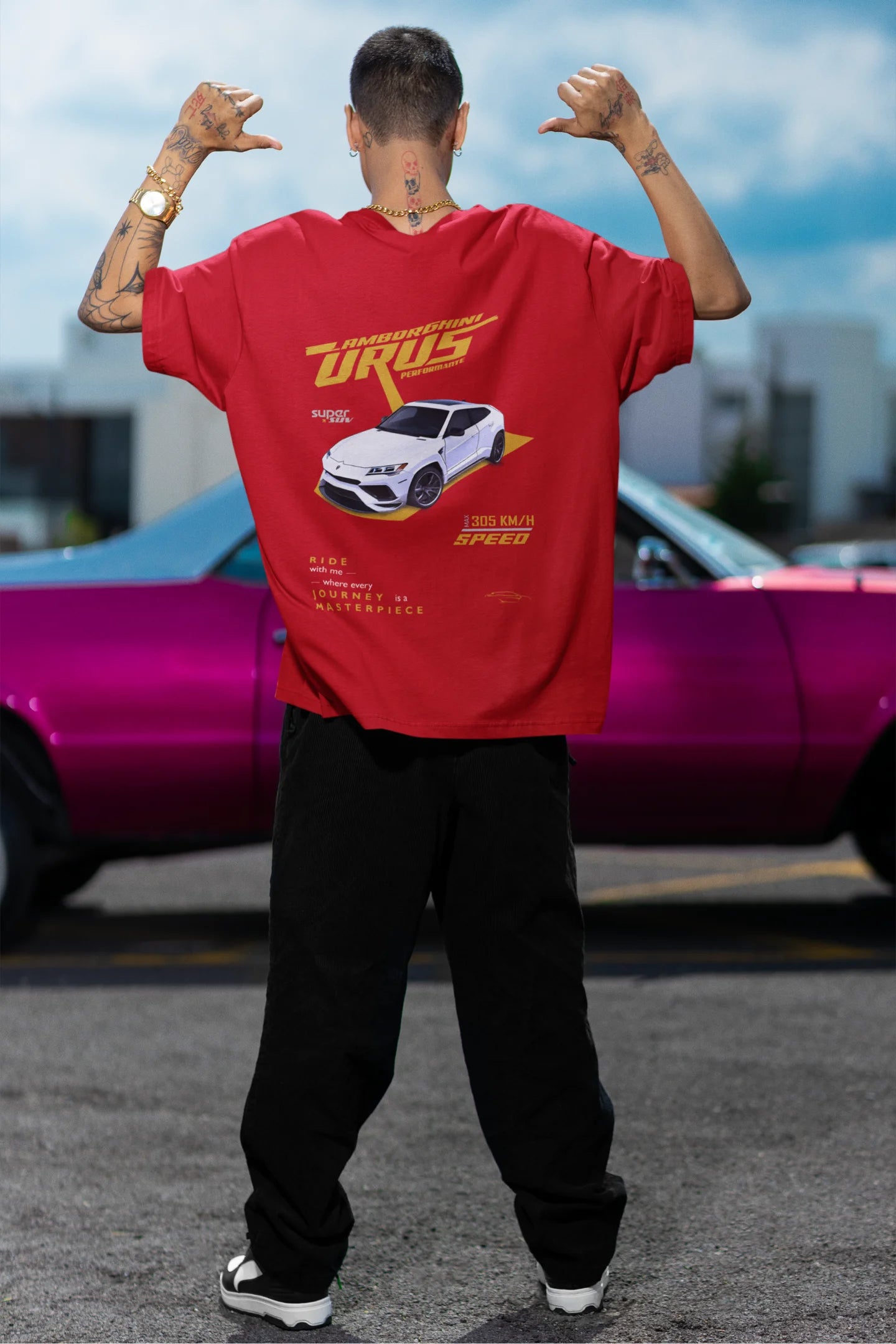 Back view of a male model wearing a red oversized t-shirt featuring a design of a Lamborghini Urus.