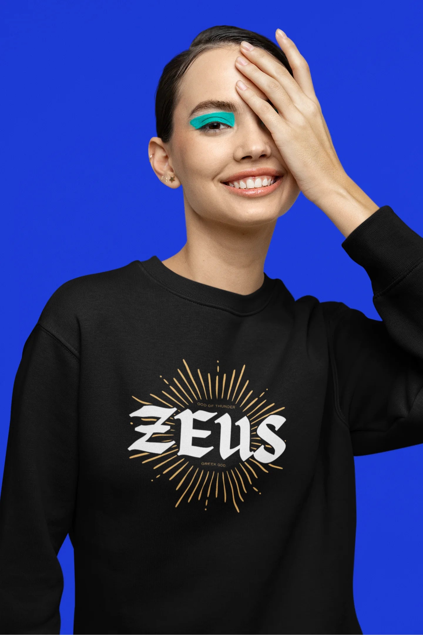 Fourth front view of a female model wearing a brutalist-inspired black sweatshirt with a stylized image of Zeus, king of the gods, in a concrete-like design.