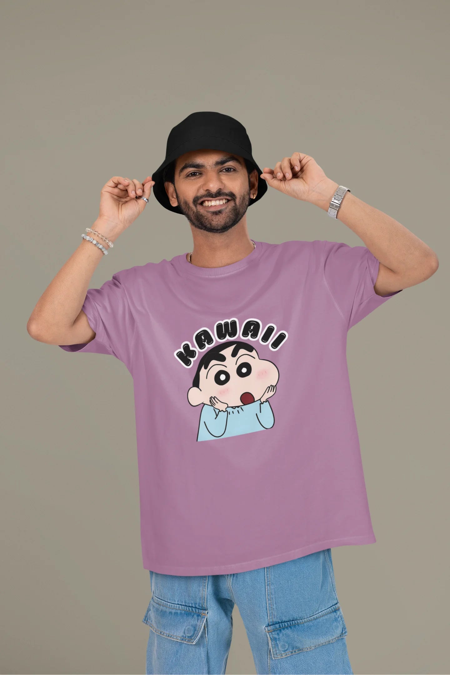 First front view of a male model wearin a dirty purple oversized t-shirt featuring Shinchan looking amazed and saying "Kawaii."
